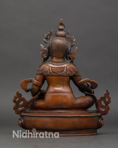 Back view of Dzambhala Buddhist statue highlighting lotus throne and protective trident, handmade using lost-wax method.