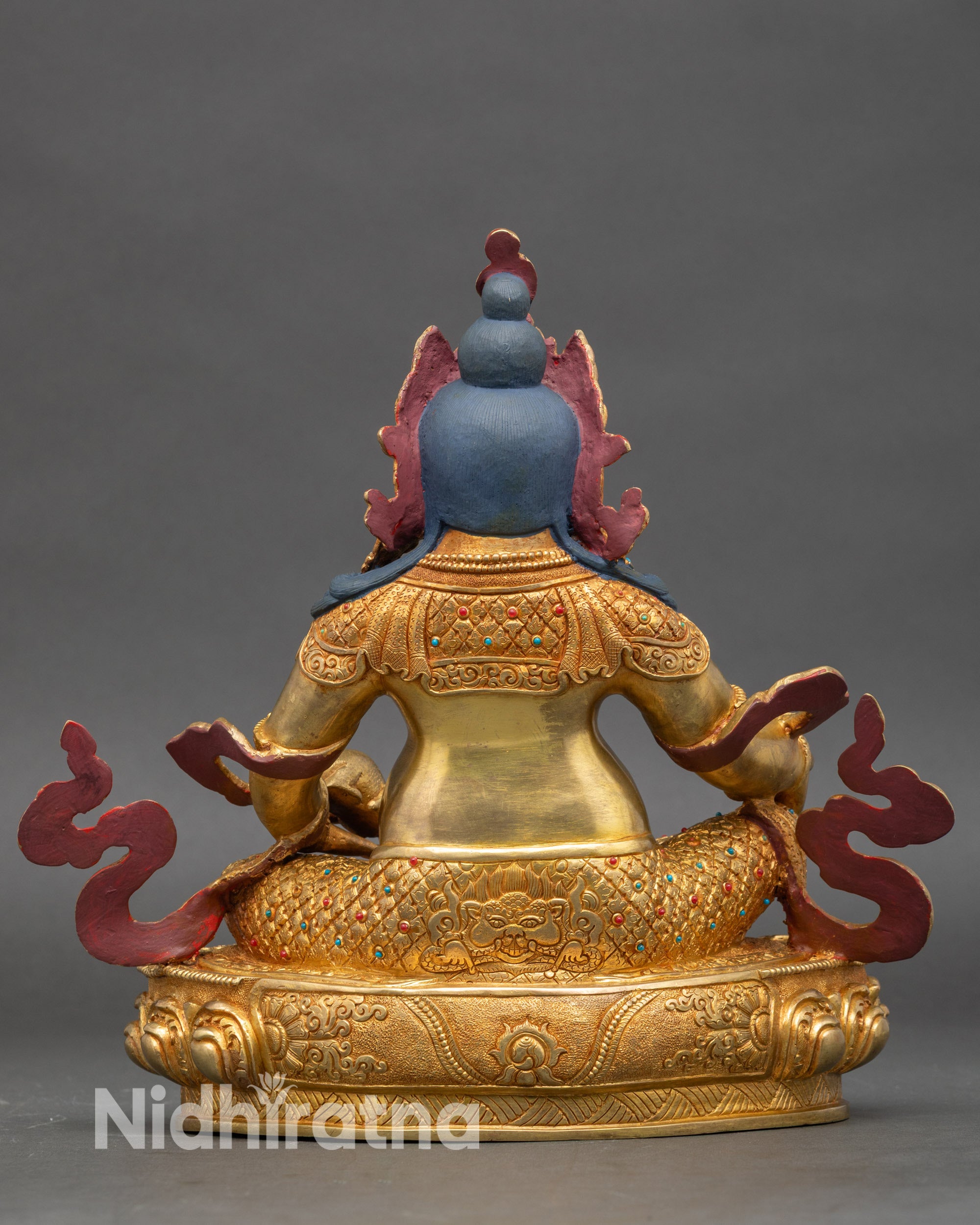 Back view of Dzambhala statue, decorated lotus pedestal and flame motifs