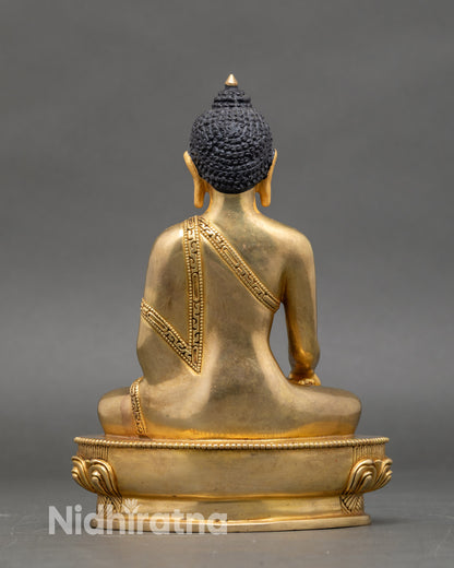 Back view of Shakyamuni Buddha statue, detailed lotus pedestal and embossed robe design