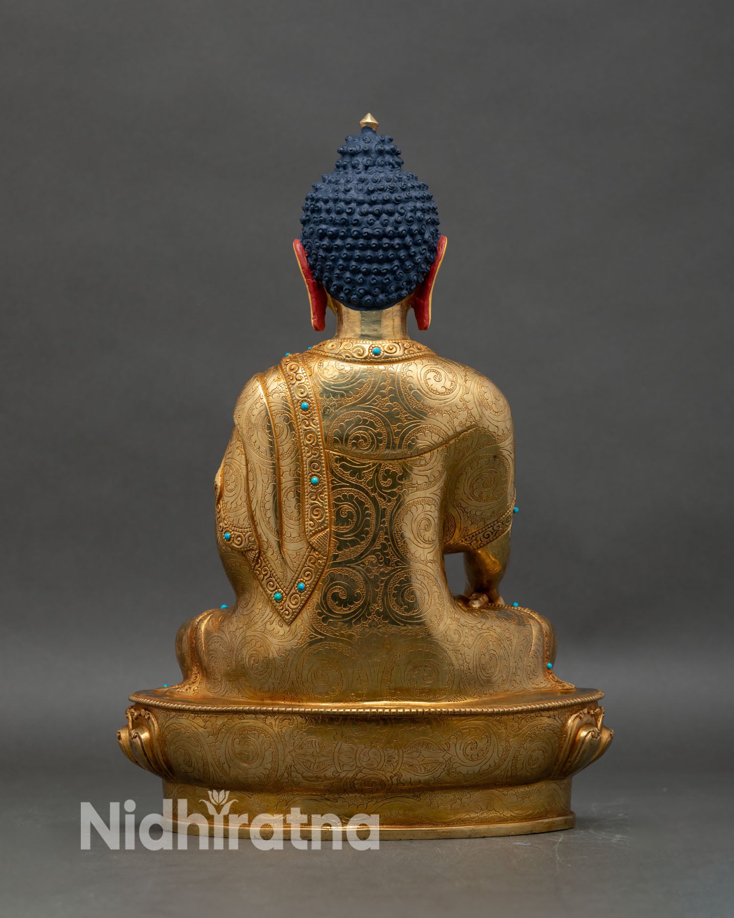 Back view of Shakyamuni Buddha statue, engraved robes and sacred lotus seat