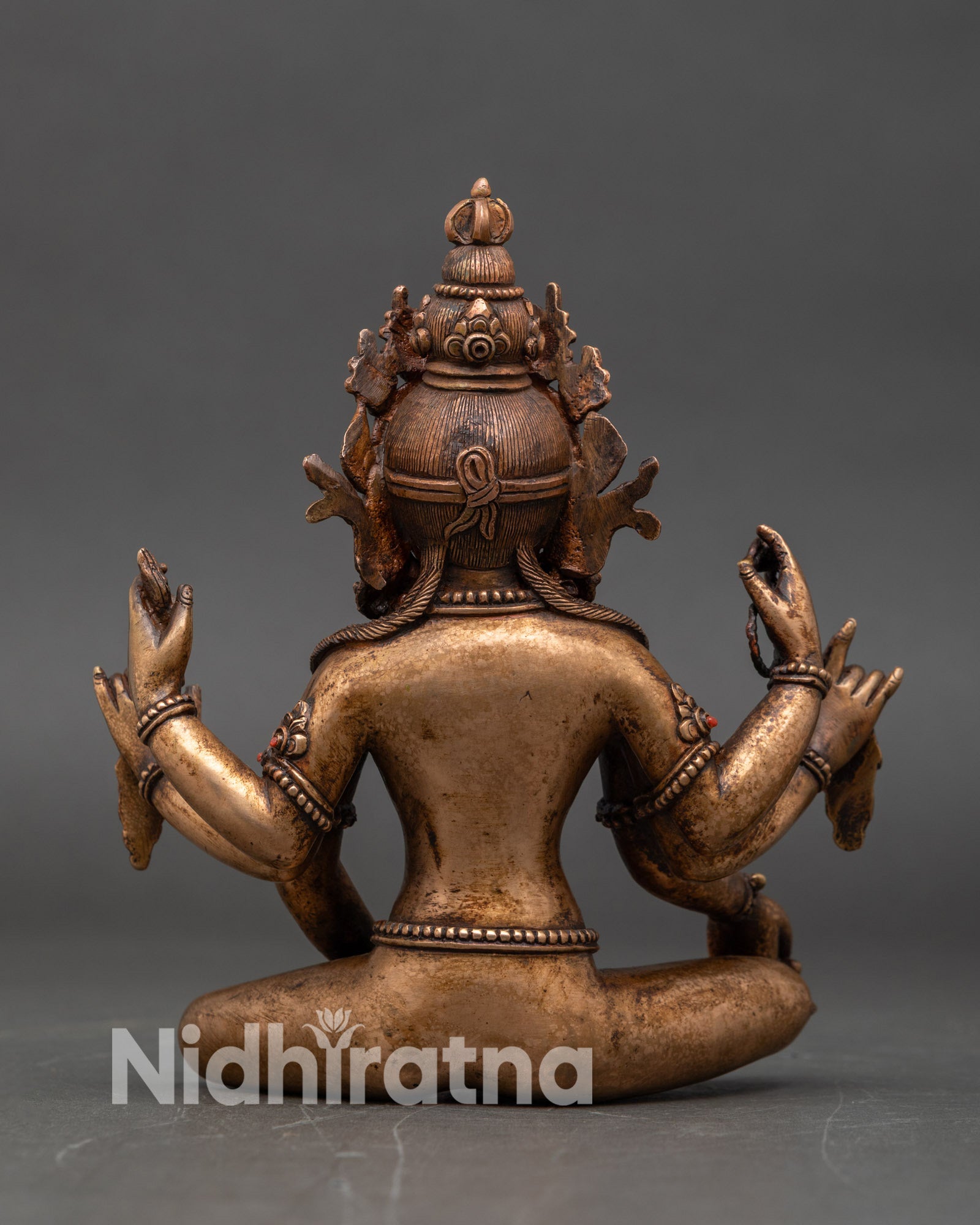 Back view of Vasudhara statue showing oxidized copper and bronze Himalayan craft
