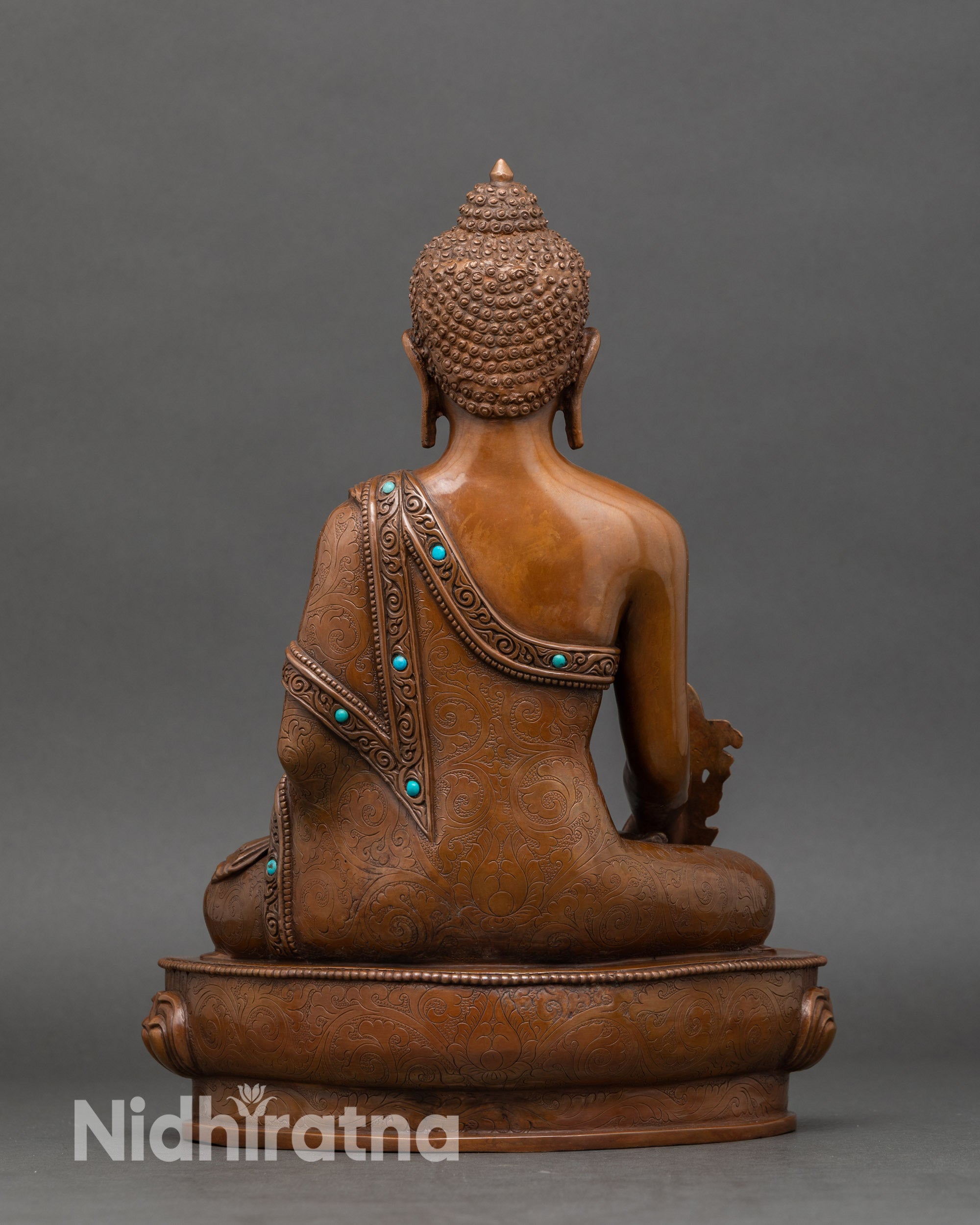 Back view of handcrafted Medicine Buddha statue showing detailed robes and lotus throne