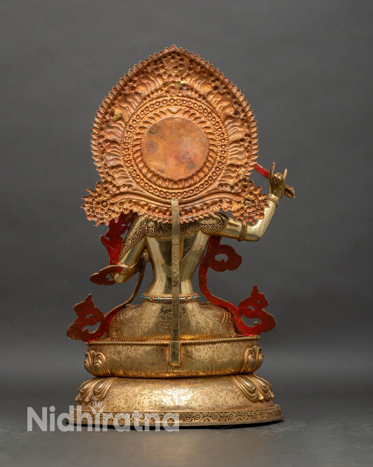 Back view of Manjushri statue showing detailed aureole structure and lotus throne engraving