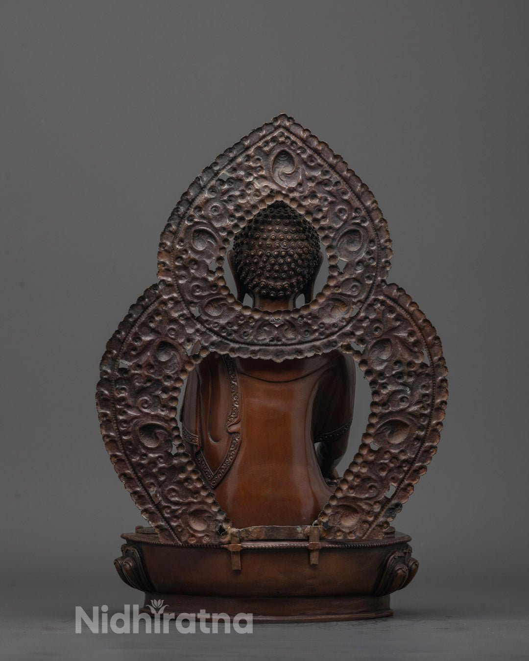 Back-view of Artisan handcrafted Siddhartha Gautama Buddha statue in oxidized copper
