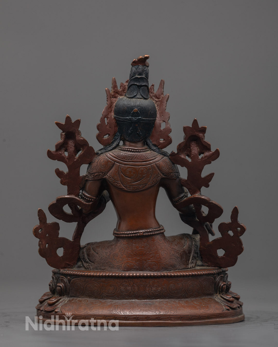 Back-view of Traditional Nepalese handmade Green Tara Buddha statue in meditative pose