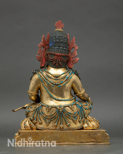 Back of Dzambhala statue showcasing intricate craftsmanship and flowing robe details