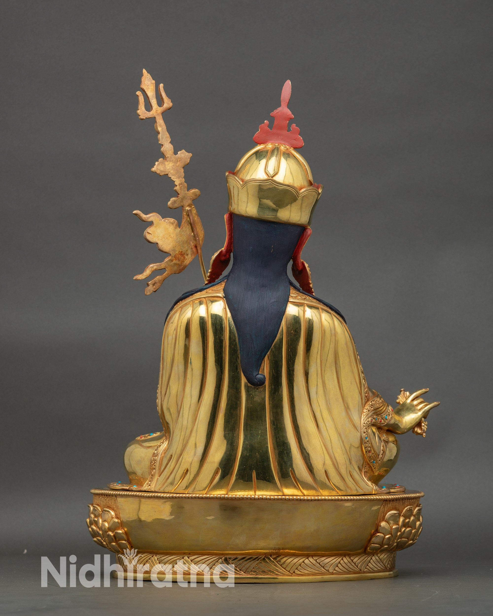 Back of Guru Rinpoche statue showing lotus throne, kasaya robe folds, and sacred motifs