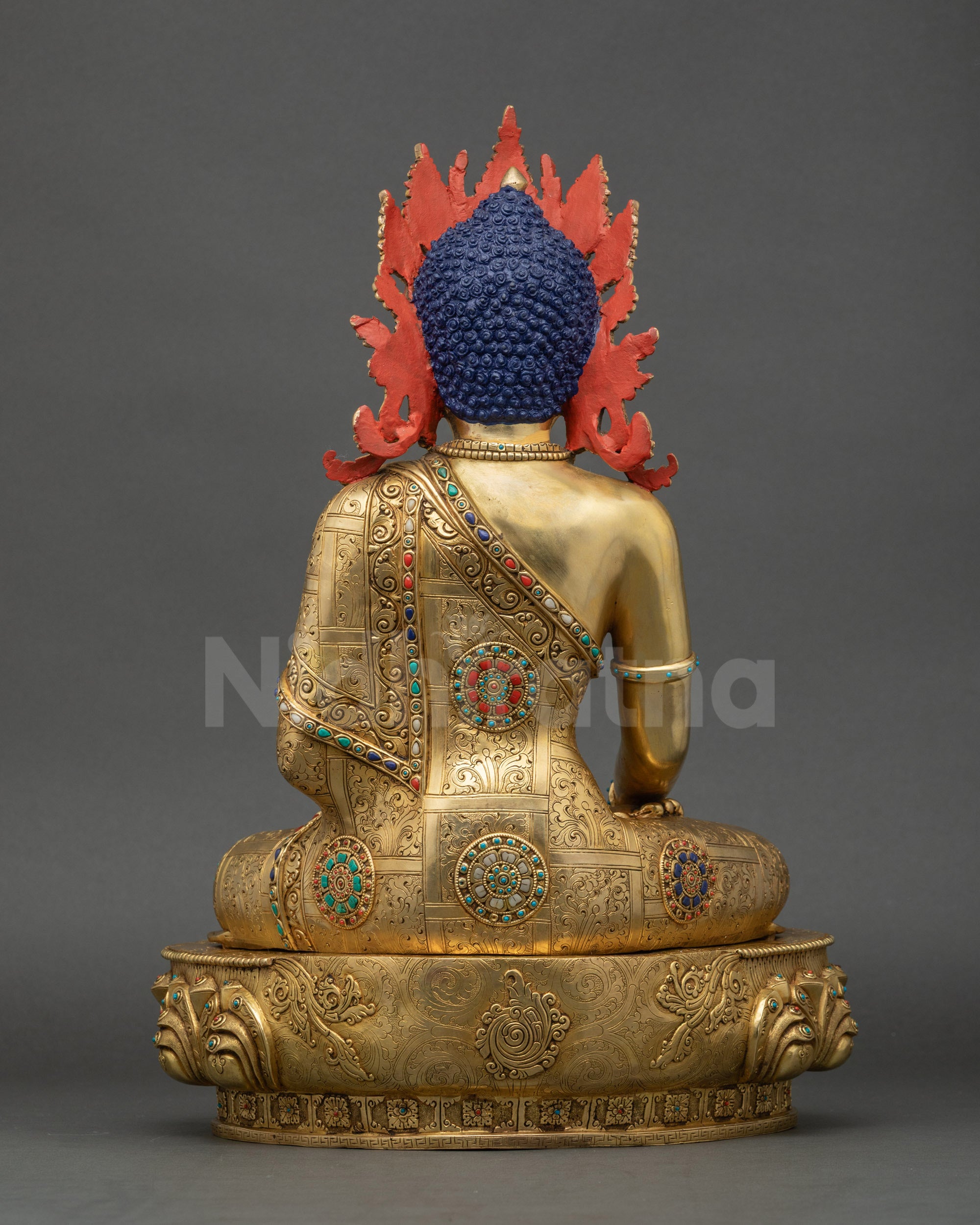 Back of Mitrugpa Buddha statue showing detailed robe carvings and gold fire-gilded craftsmanship.