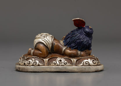 Sleeping Bal Ganesh sculpture showing smooth oxidized copper texture and hand-painted silver accents