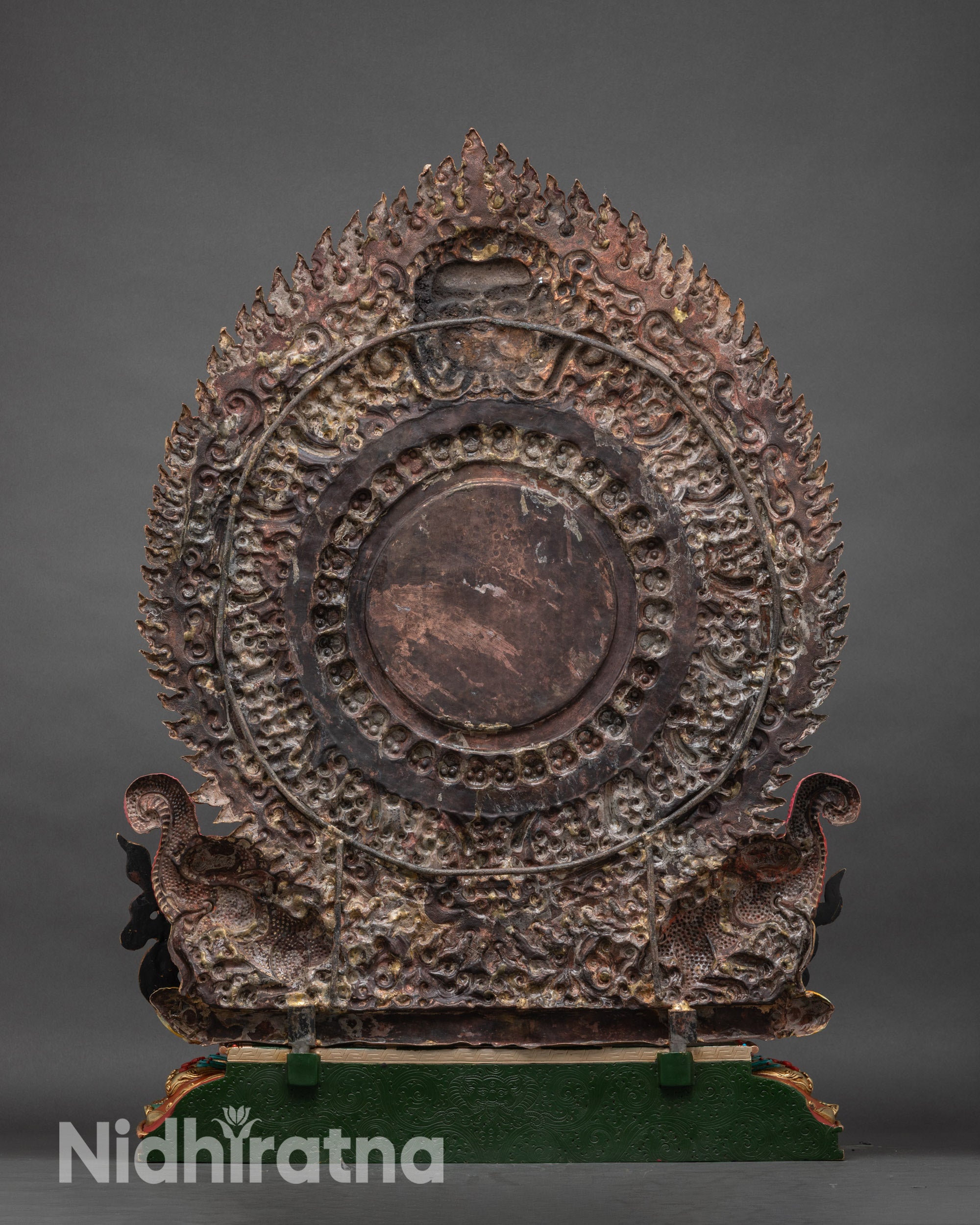 Back of Vajrapani statue showing ornate Garuda floral halo and lotus pedestal with carvings