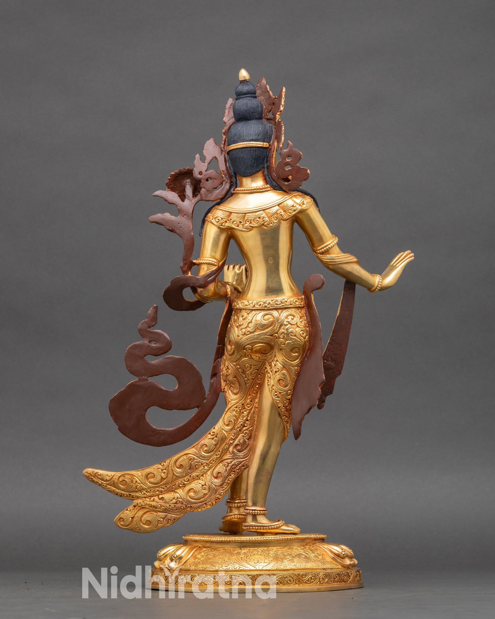 Back of White Tara statue showing detailed floral carvings and ornate crown