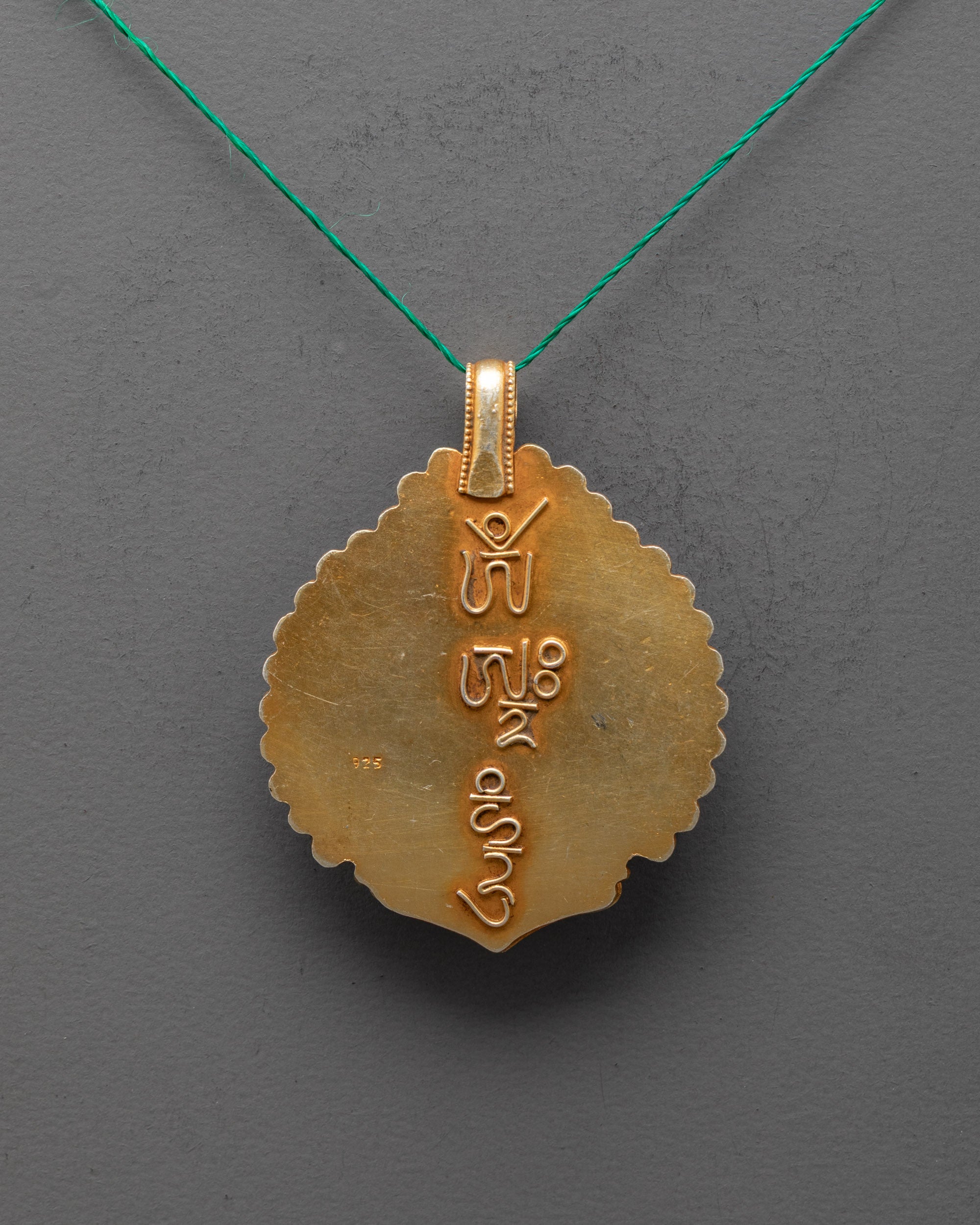 Back of handcrafted White Tara locket revealing detailed metalwork – Nepalese Buddhist amulet symbolizing compassion, longevity, and protection.