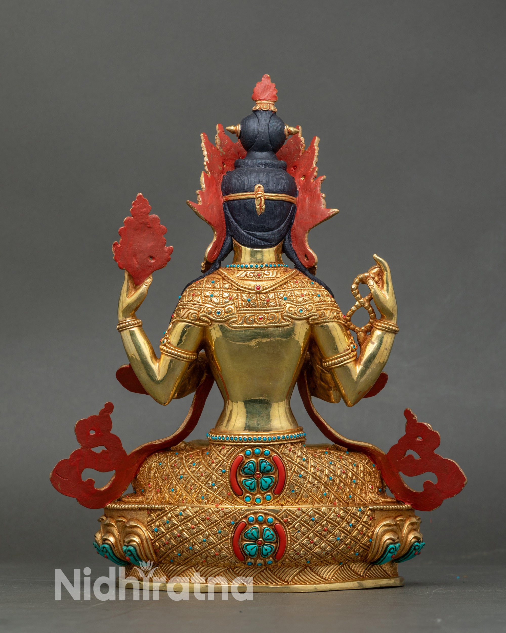 Side view Chenrezig sculpture seated on double lotus throne with flowing robes and detailed carving