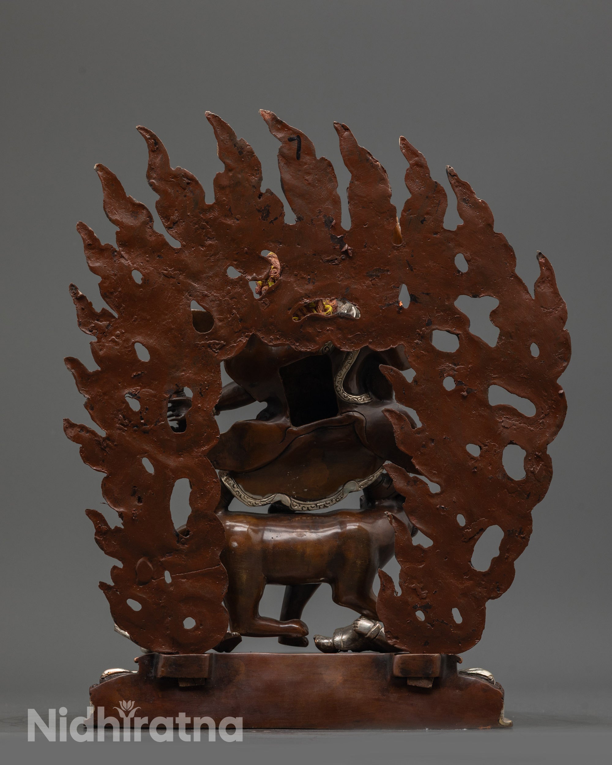 Back view Dorje Drolo statue with oxidized copper body and silver-plated halo of flames