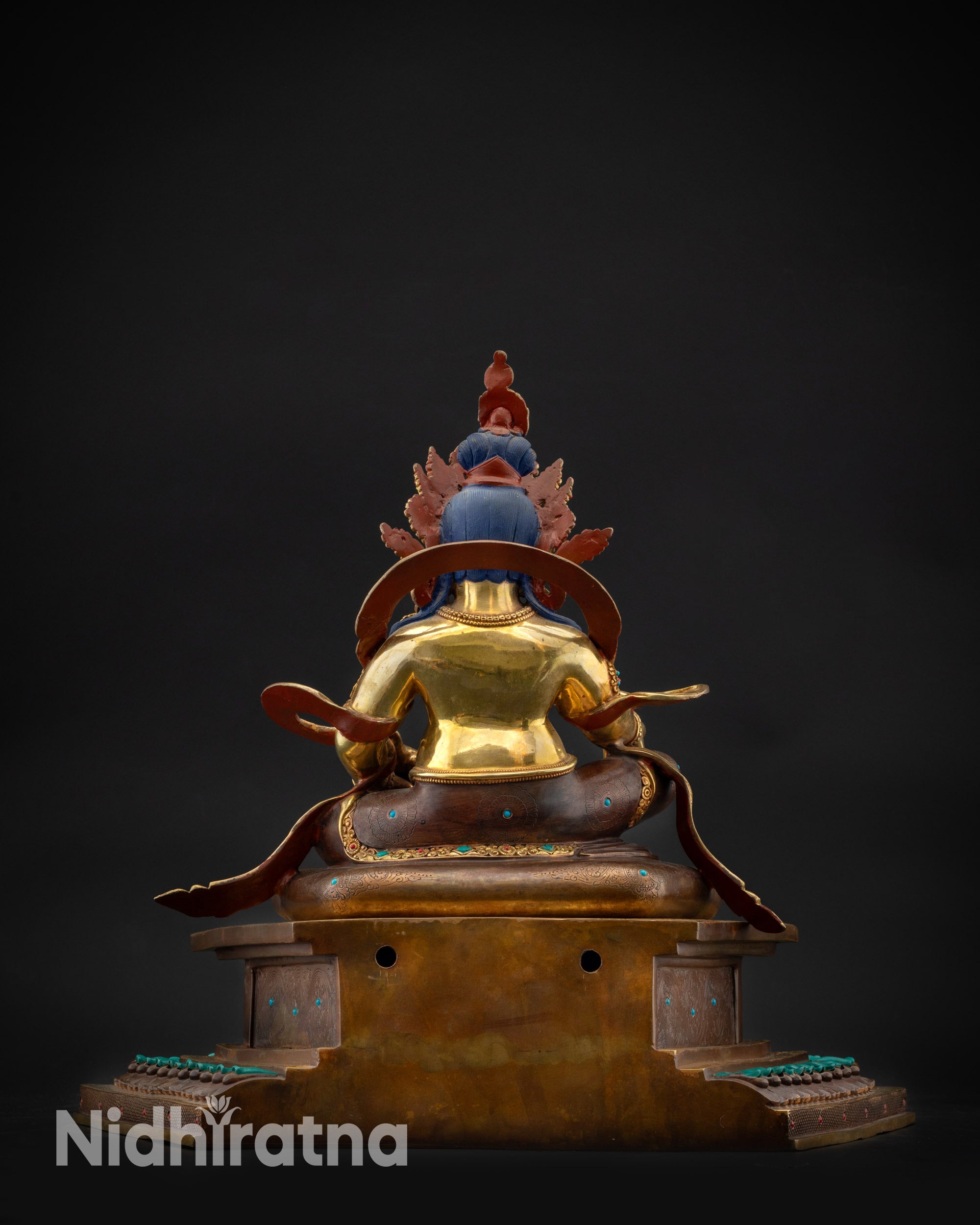 Back view Dzambhala statue showing carved robe folds and oxidized copper throne