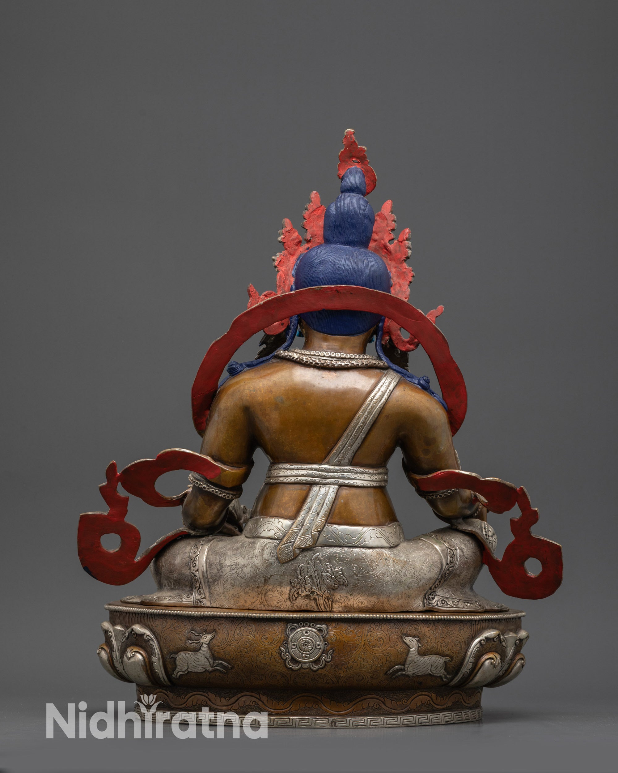 Back view Dzambhala statue showing detailed carvings, silver-plated decorations, and ornaments