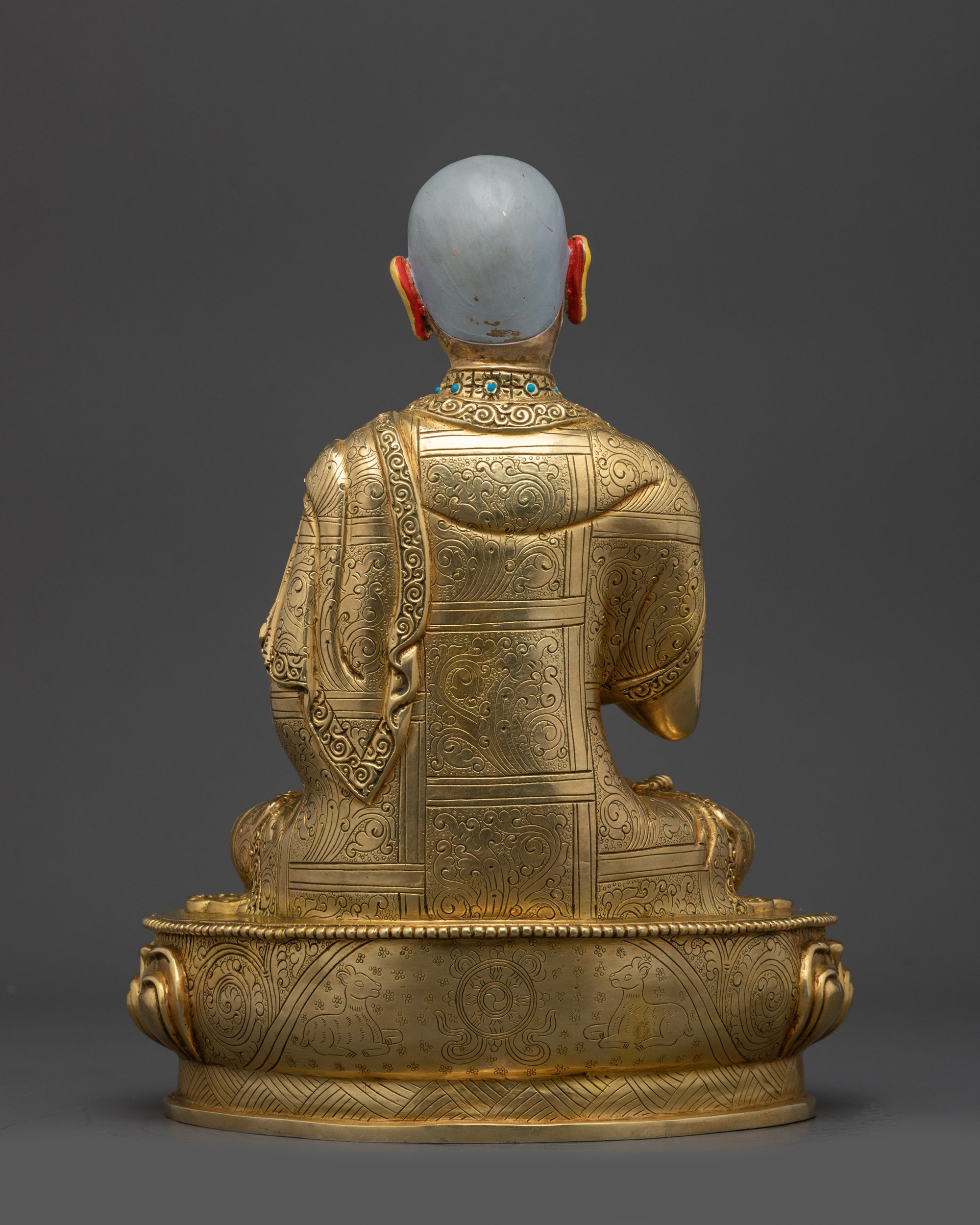 Back view Gyaltsab Je statue with intricate carvings on robe and pedestal