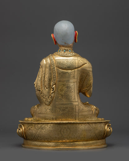 Back view Gyaltsab Je statue with intricate carvings on robe and pedestal