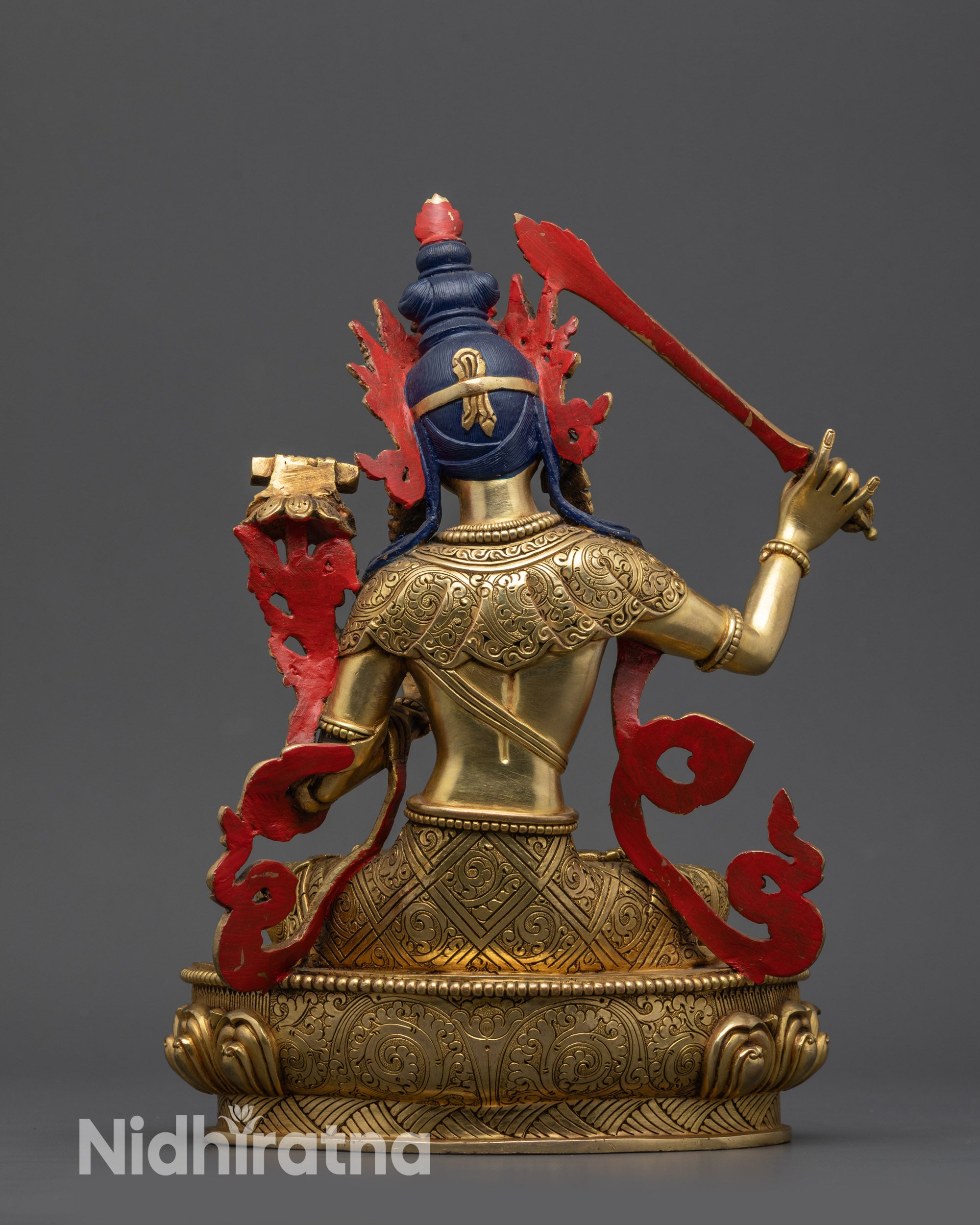 Back view Manjushree statue showing intricate swirling robe patterns and lotus carvings
