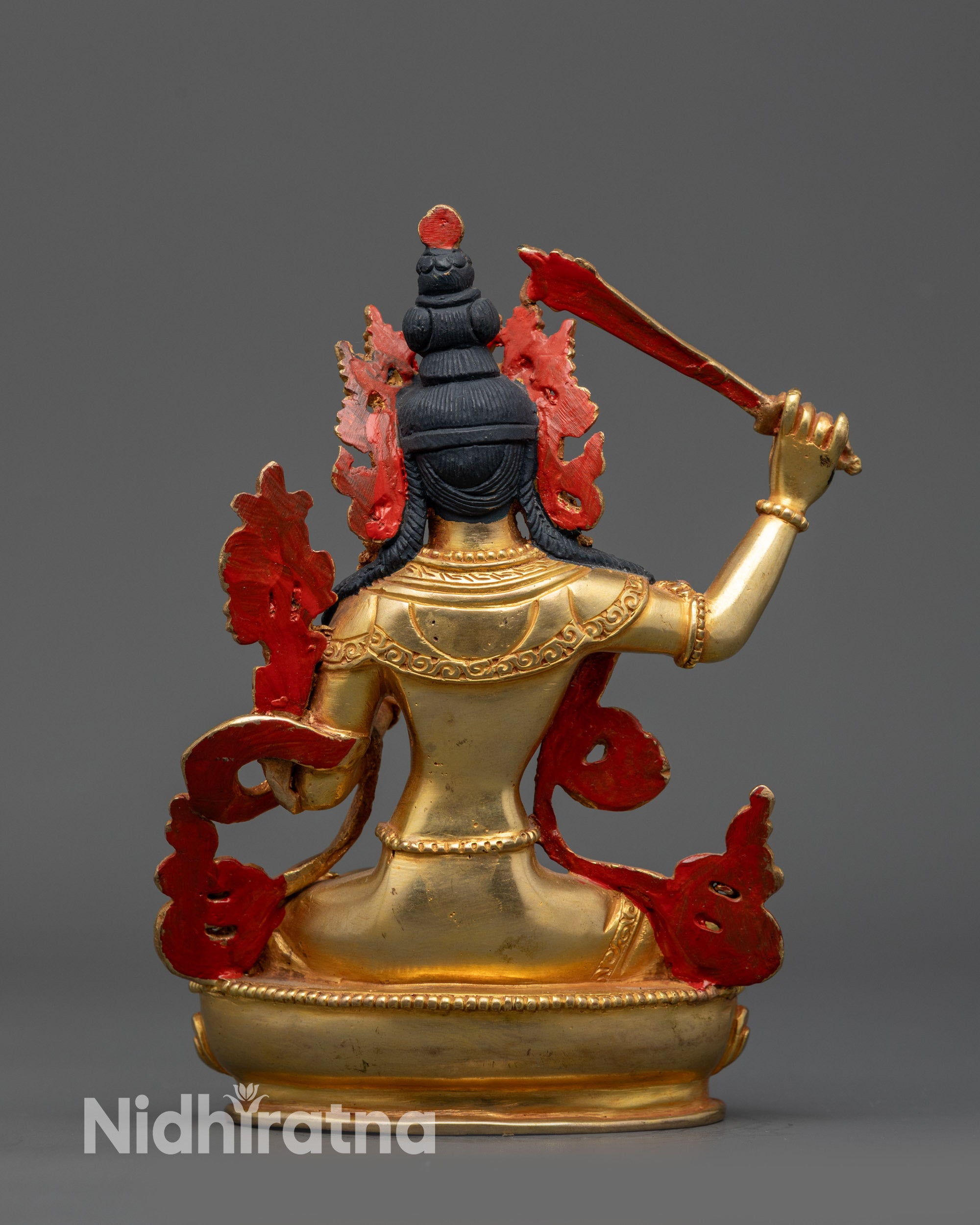 Back view Manjushri statue showing elaborate earrings and sutra topper