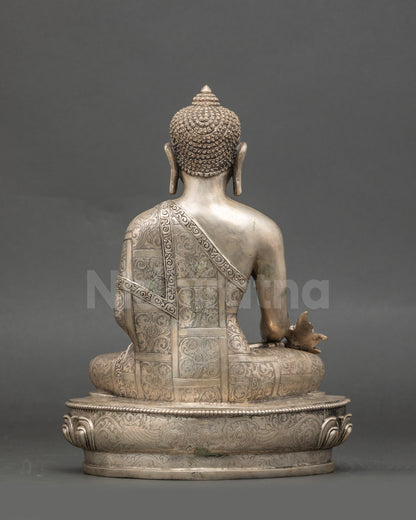 Back view of the Medicine Buddha statue seated, intricate silver-plated Nepalese craftsmanship