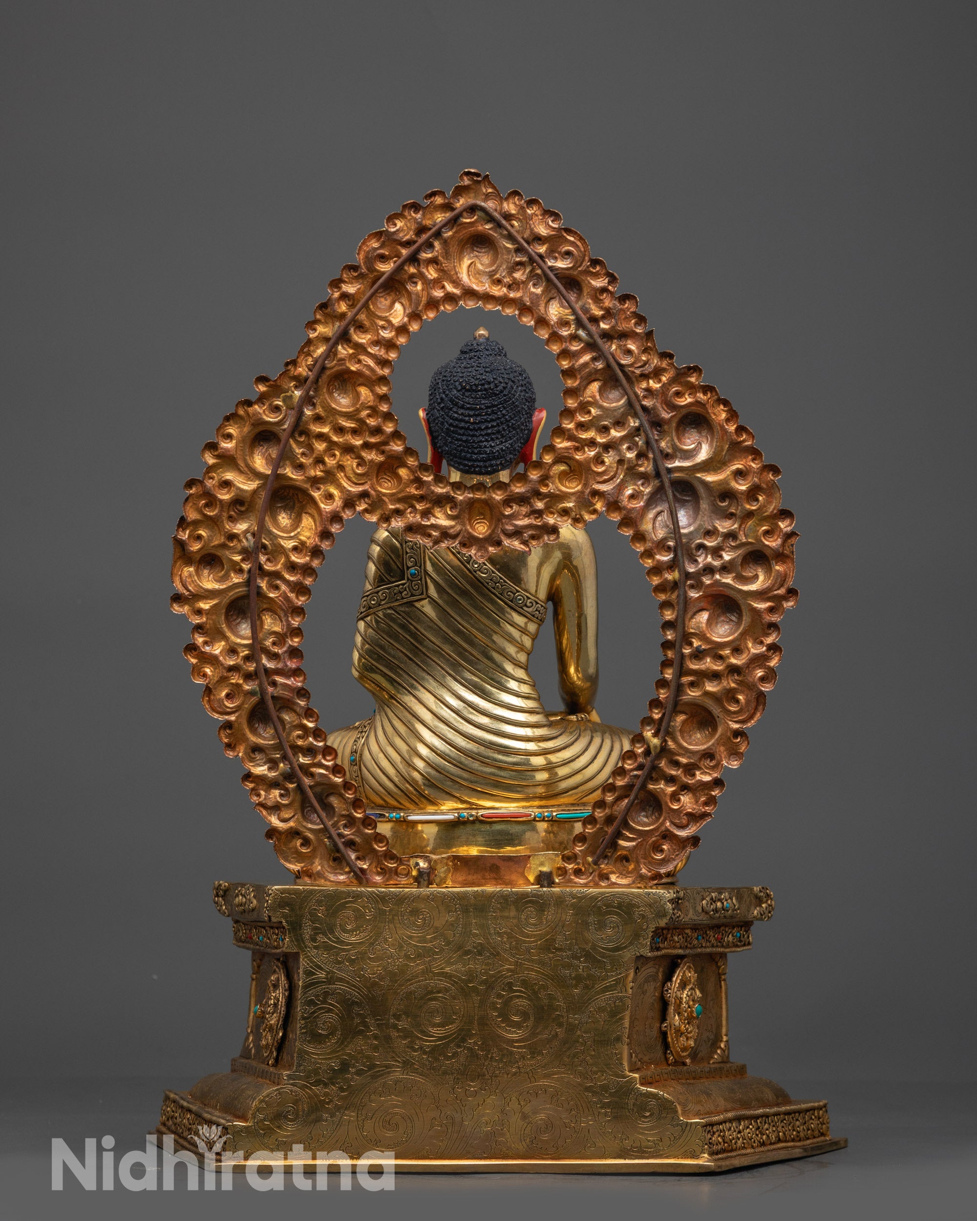 Back view Shakyamuni Buddha statue adorned with turquoise, coral, white, and lapis lazuli stones