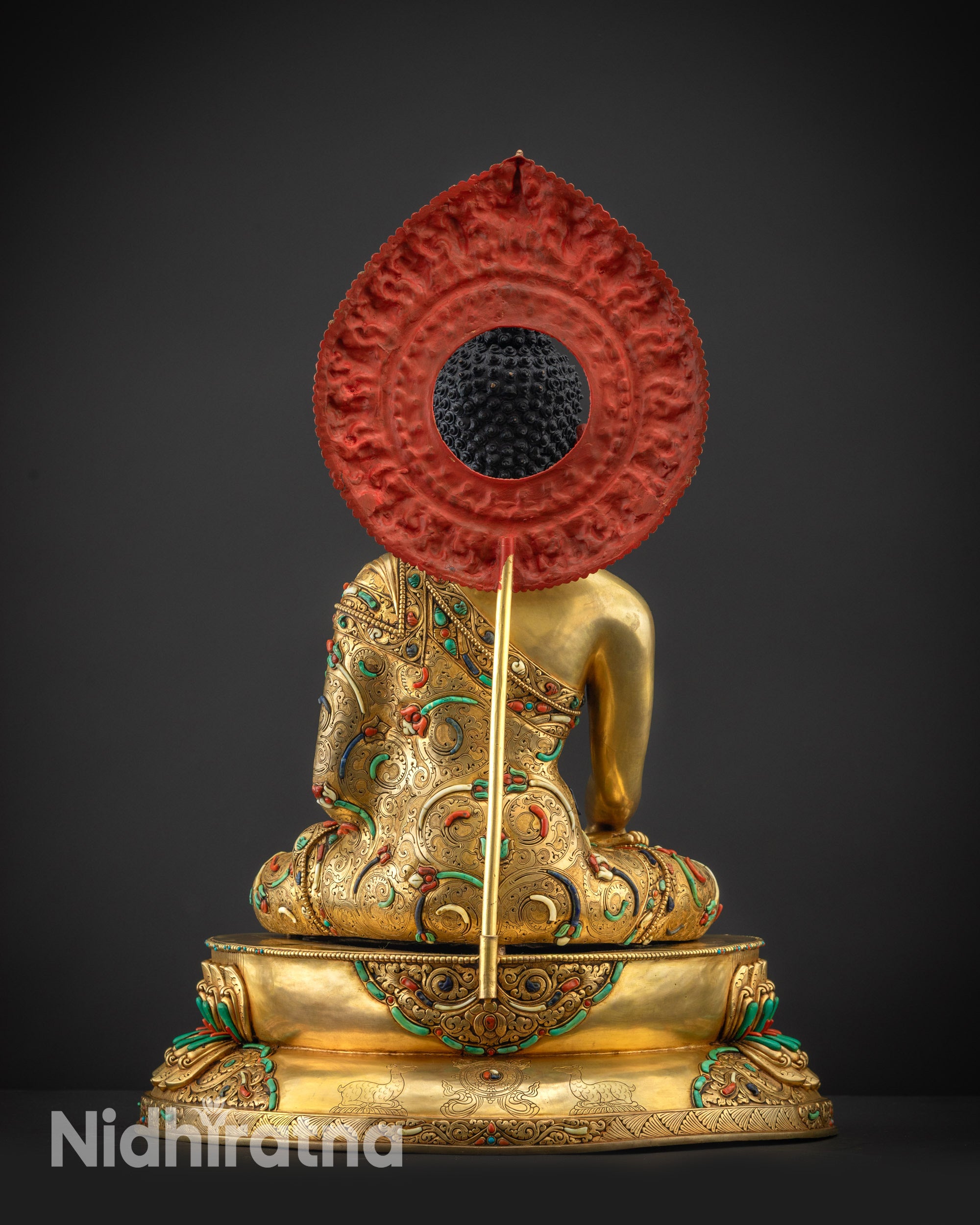 Back view Shakyamuni Buddha statue showing detailed robe and halo ornamentation
