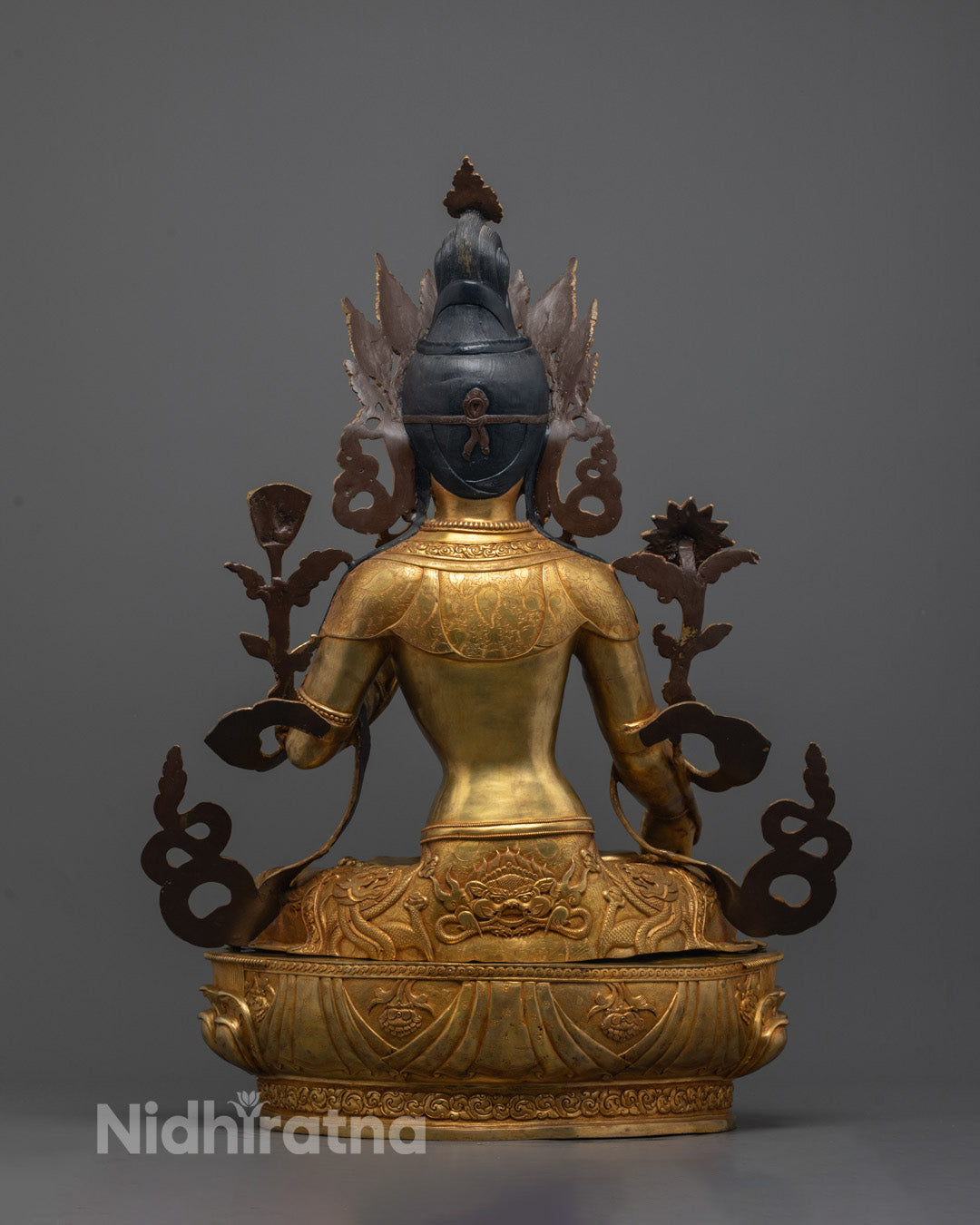Back view, White Tara statue, intricate lower garment with dragon-like head carving.