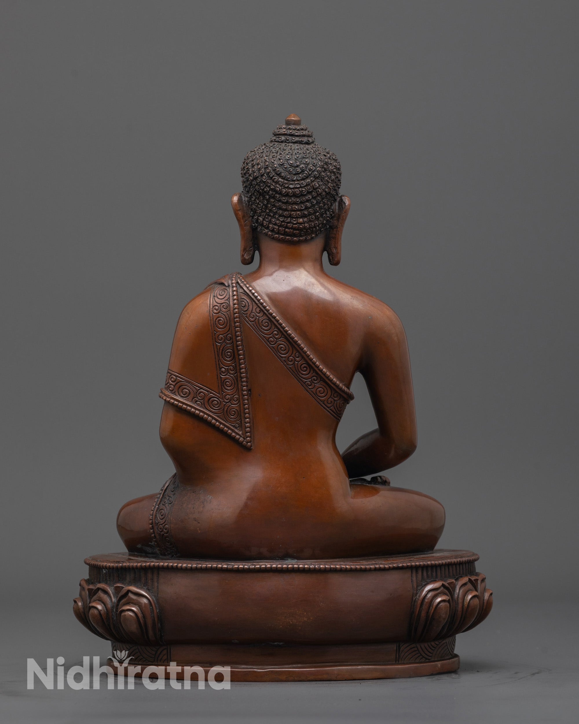 Back view of Amida Buddha sculpture highlighting rich brown oxidized finish and texture