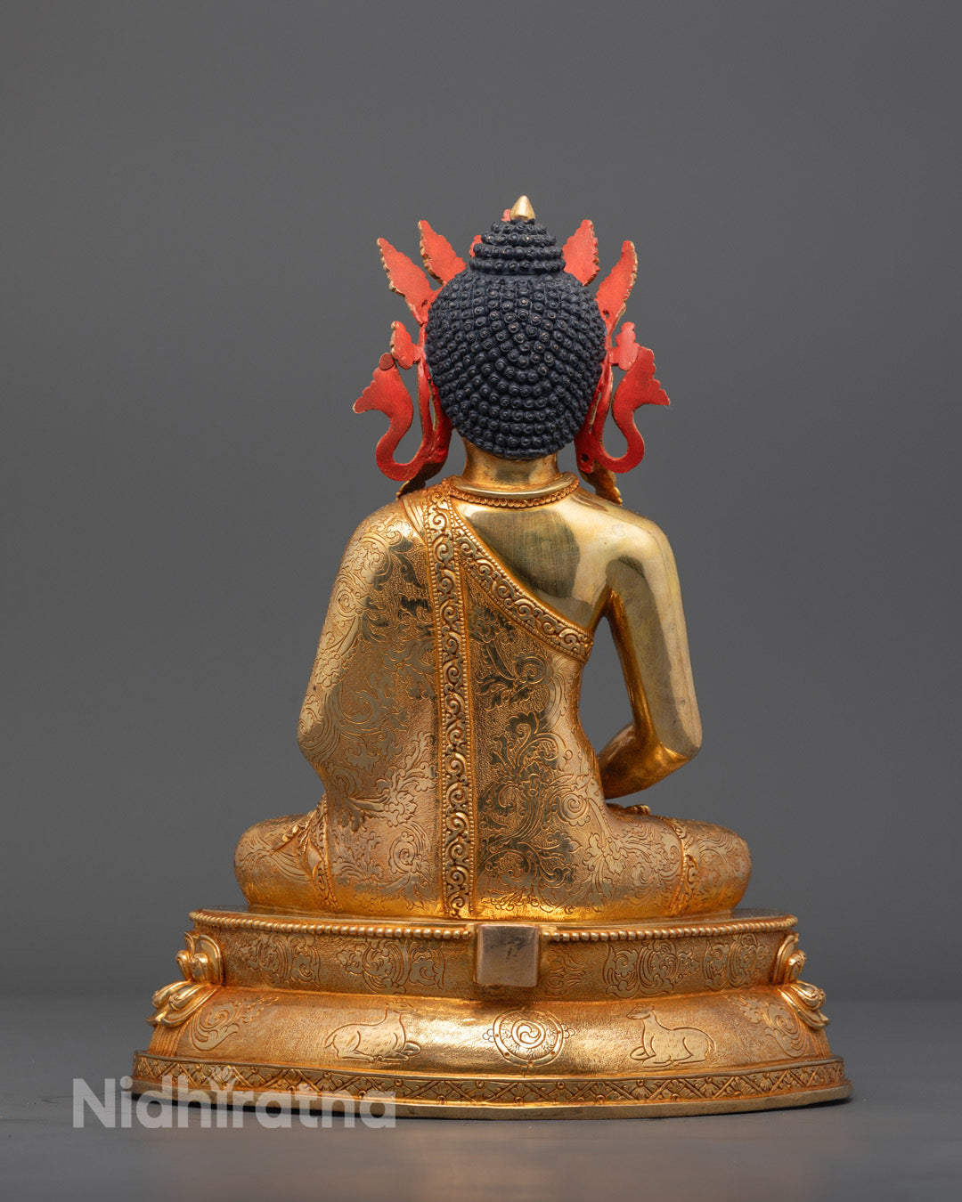 Back view of Amida Buddha statue highlighting intricate robe carvings and halo design
