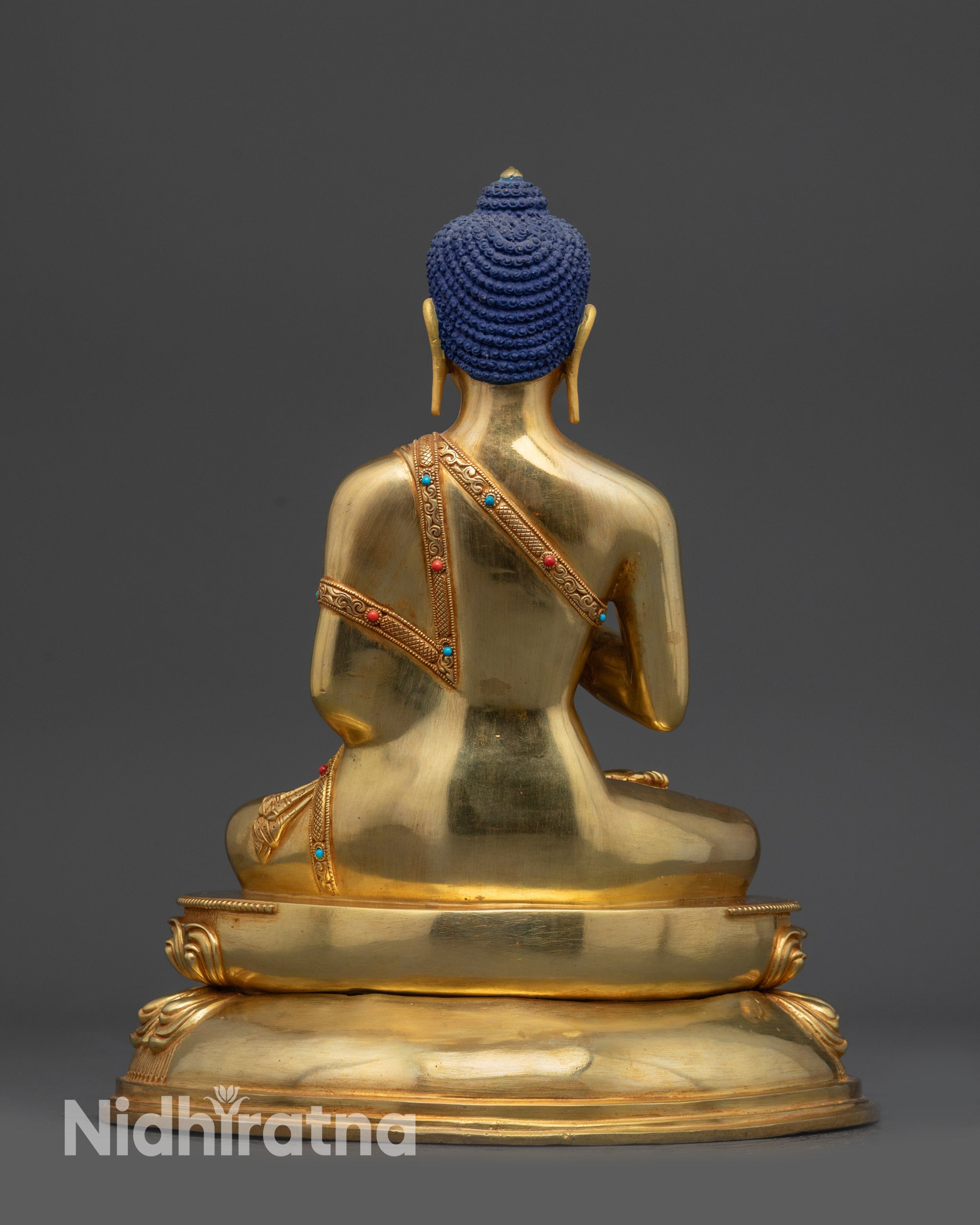 Back view of Amoghasiddhi Buddha statue showing polished robe and intricate lotus pedestal