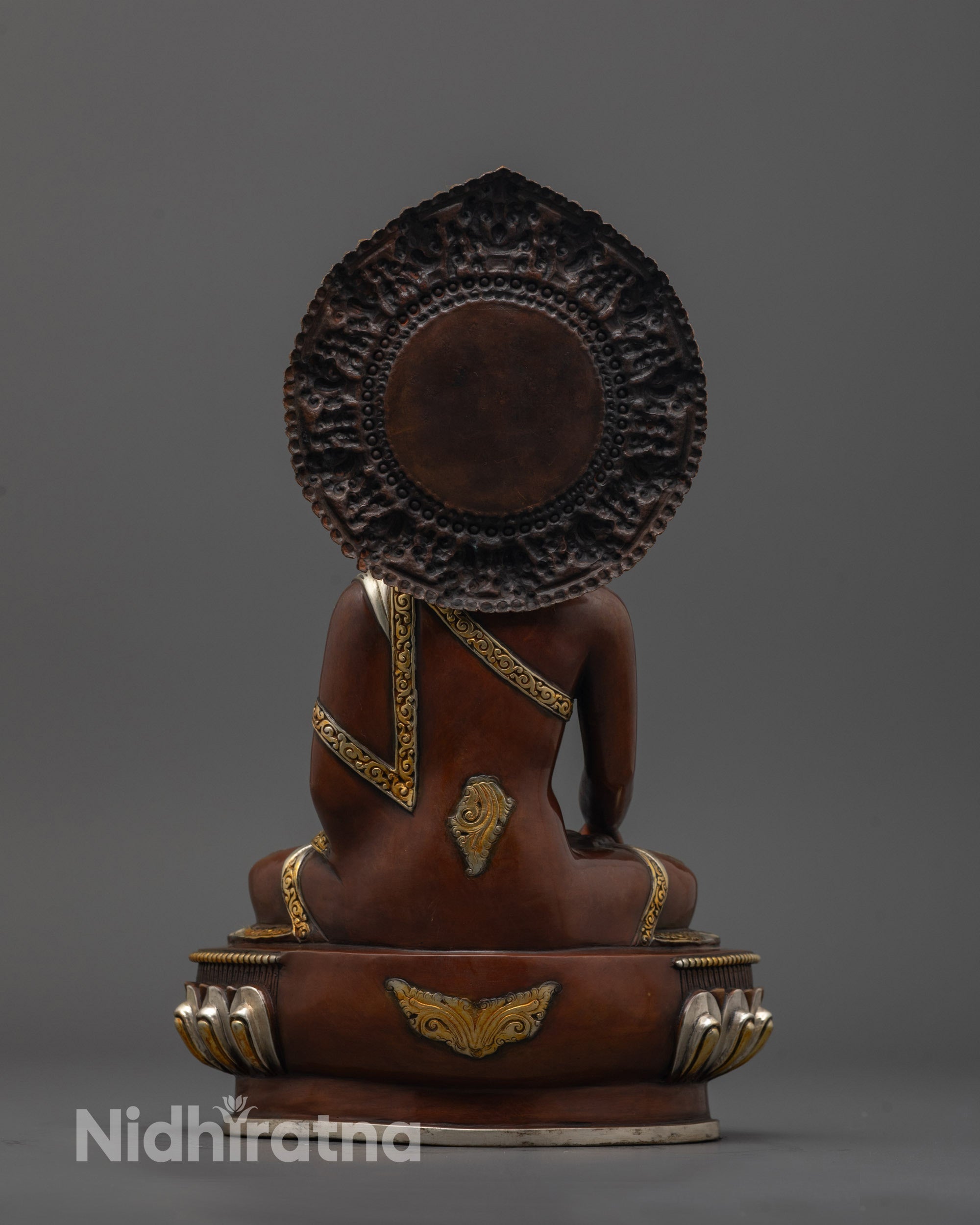 Back view of Buddha Sculpture showing intricate carvings and gold & silver-plated finish on halo and robe