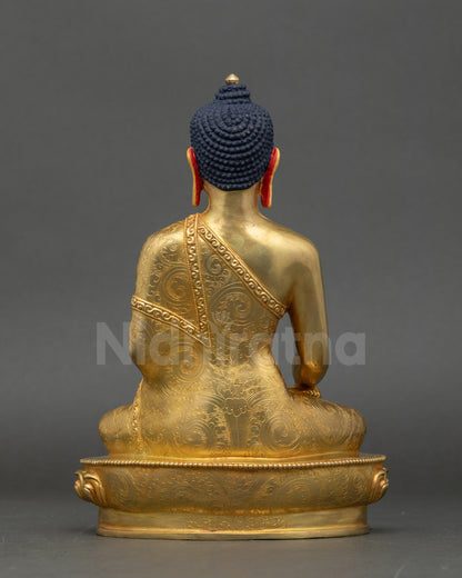 Back view of Buddha Shakyamuni sculpture highlighting patterned robe and lotus base