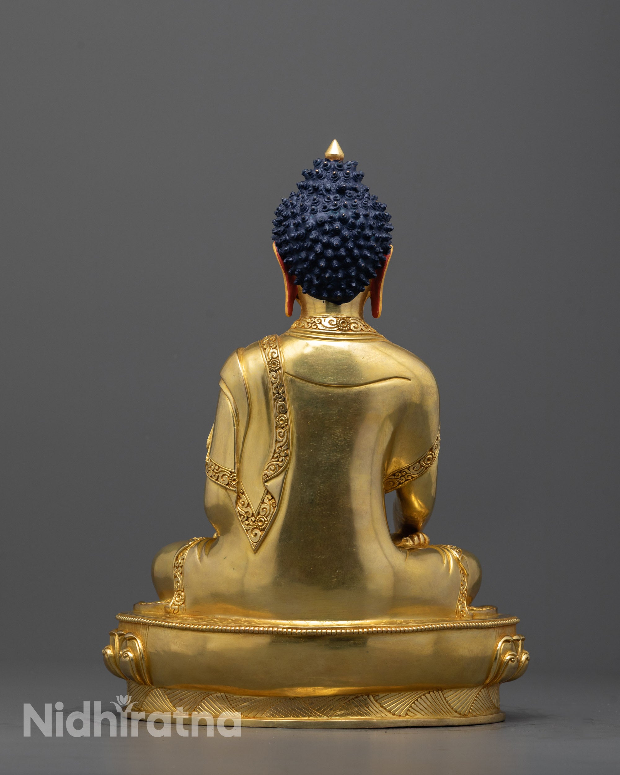 Back view of Buddha Shakyamuni statue showcasing precise carvings and copper base finish