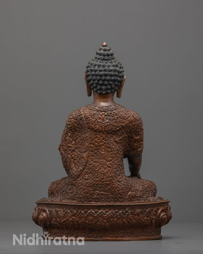 Back view of Buddha statue displaying intricate patterns and miniature deities on robe and seat.
