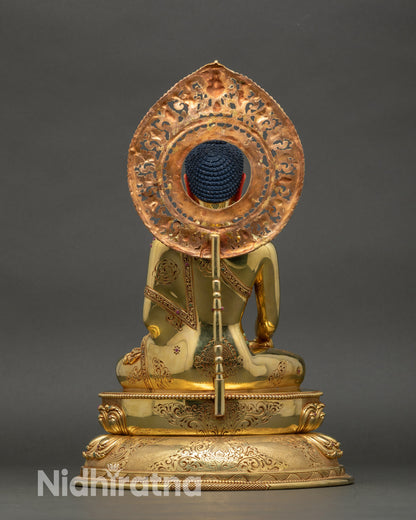 Back view of Buddha statue, engraved lotus base and ornate copper details