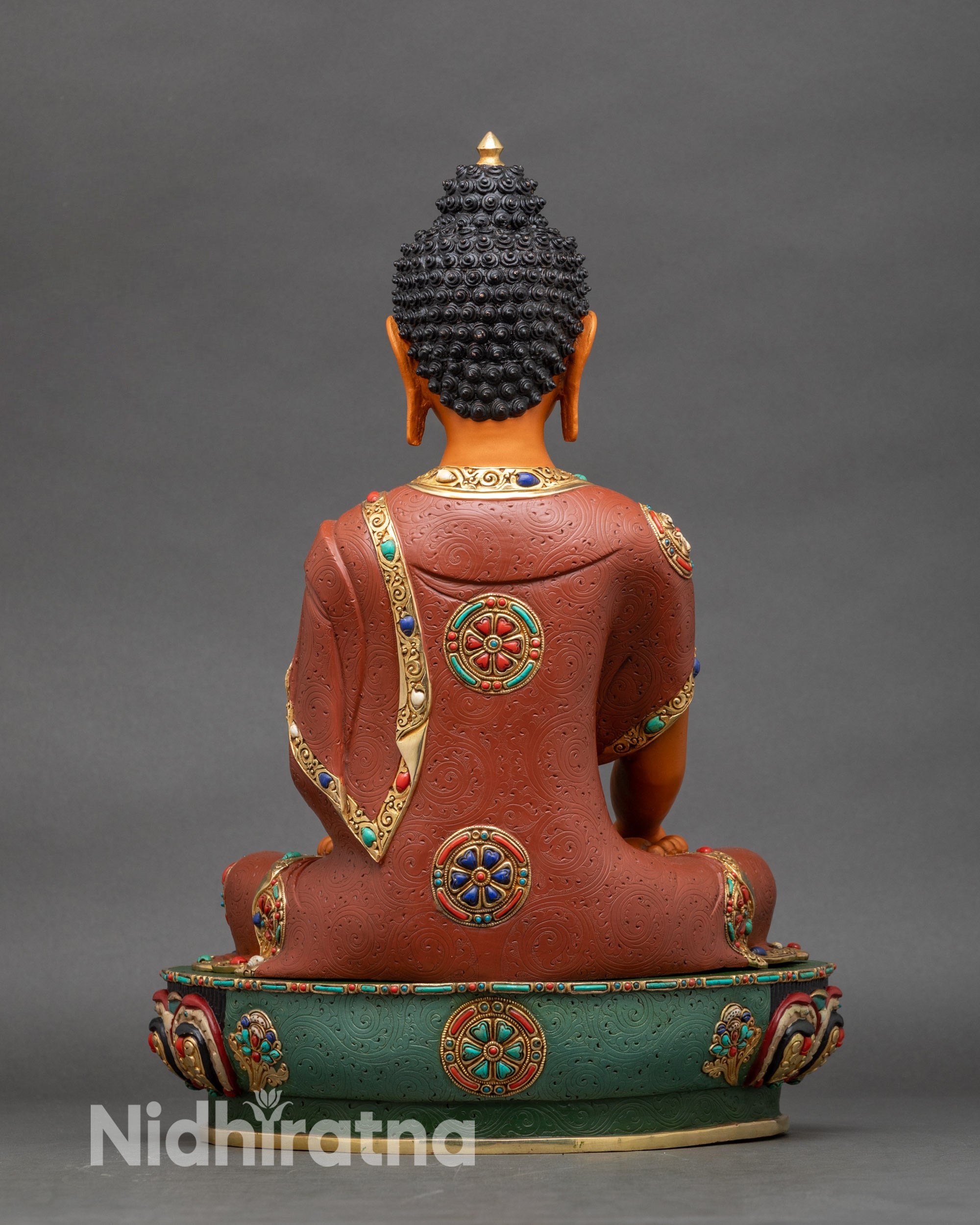 Back view of Buddha statue showing detailed robe folds and ornate lotus pedestal