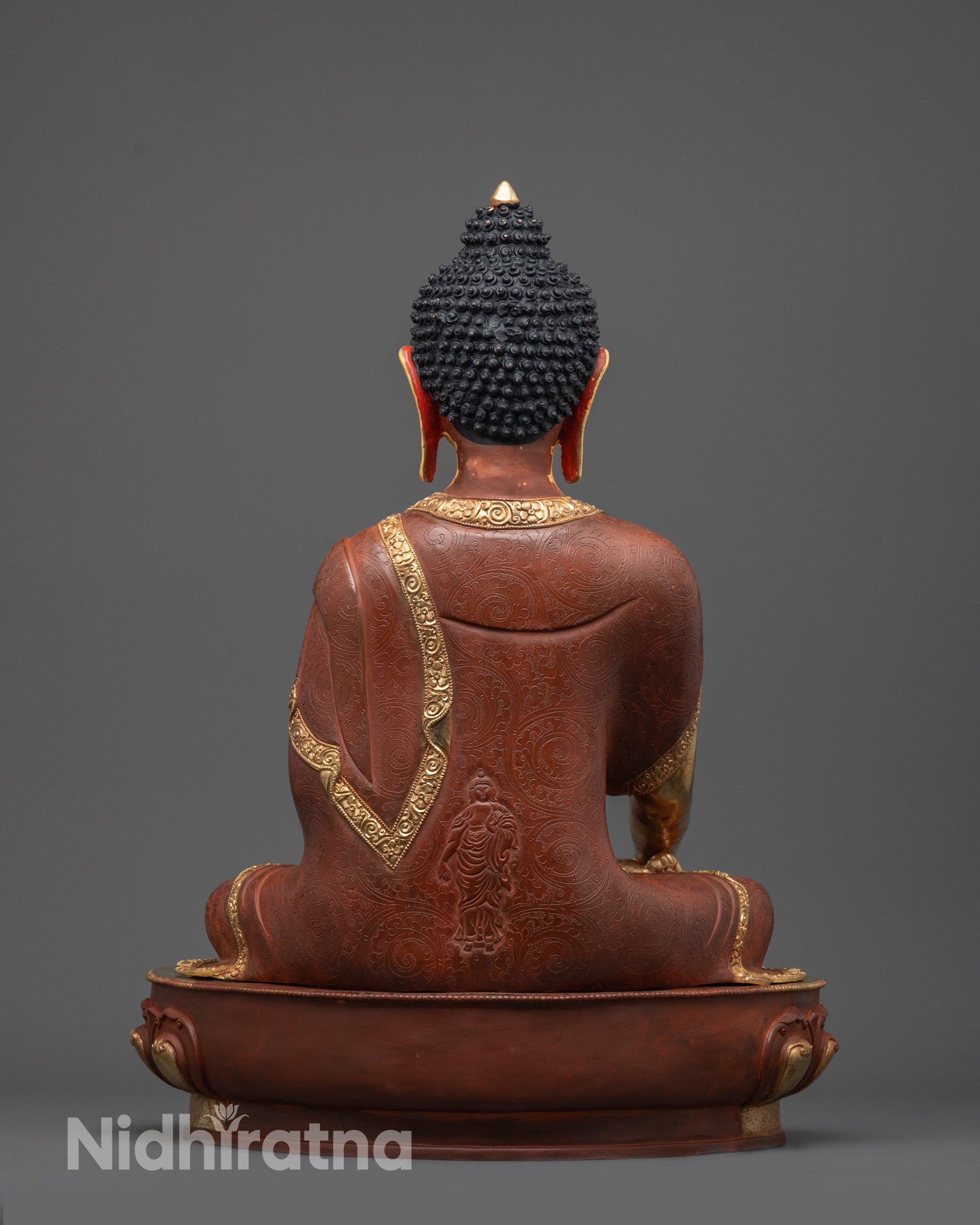 Back view of Buddha statue showing intricate gold fire-gilded body and robe design
