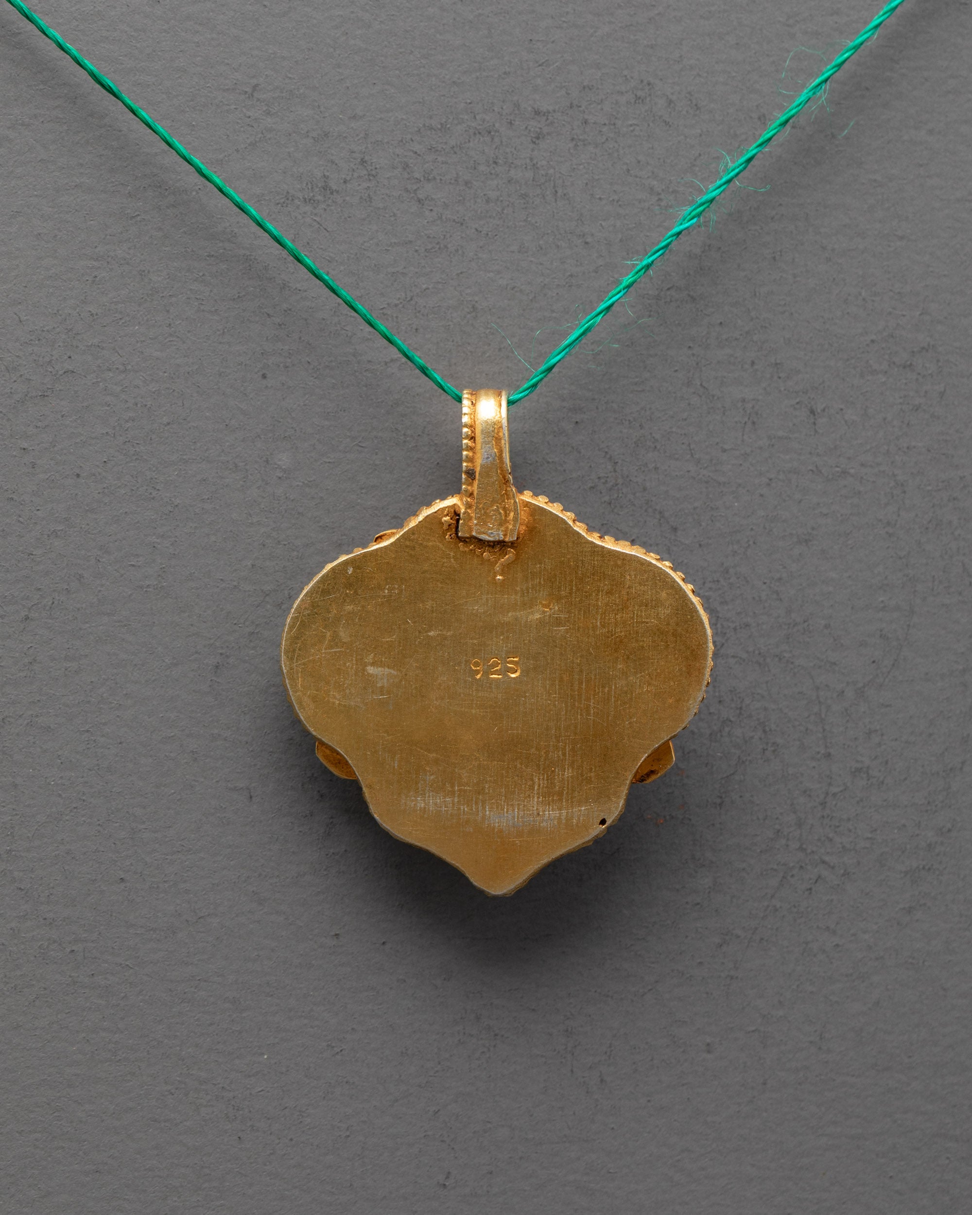Back view of Chenrezig locket highlighting gold-gilded craftsmanship – sacred Buddhist pendant made in Patan, Nepal.