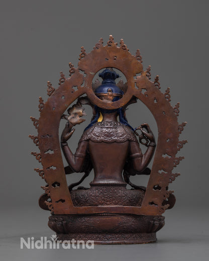 Back view of Chenrezig statue showing oxidized copper body and detailed robe texture