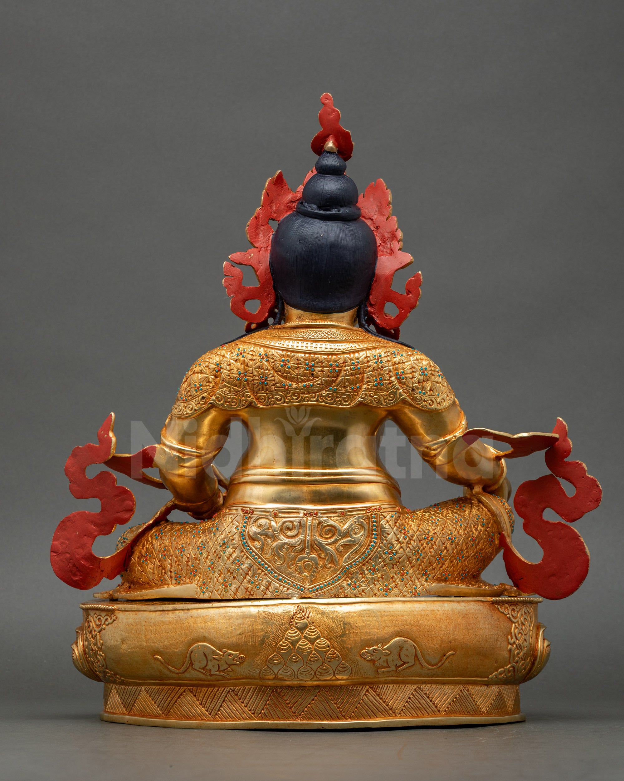 Back view of Dzambhala Statue intricate carvings on garments and lotus base