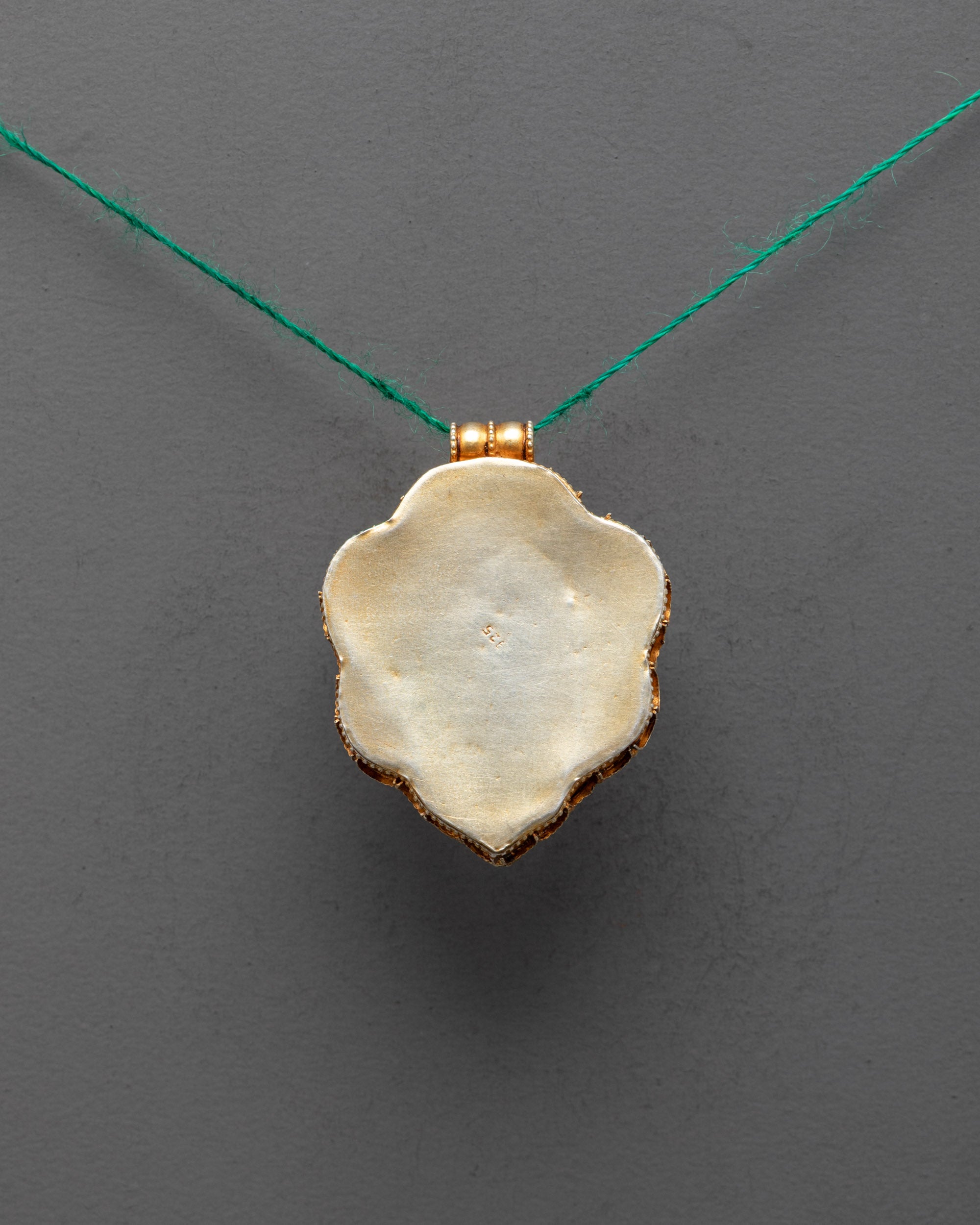 Back view of Green Tara locket pendant with premium filigree carving and gold plating
