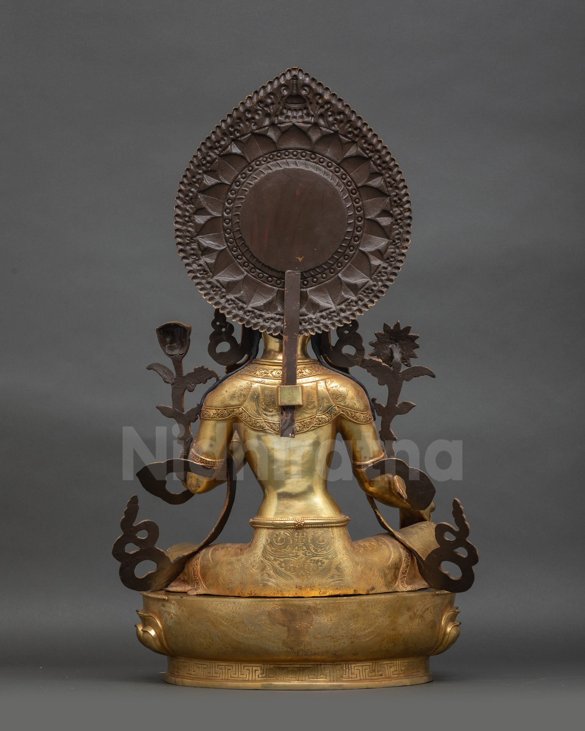 Back view of Green Tara sculpture showing carved jewelry and lotus seat patterns