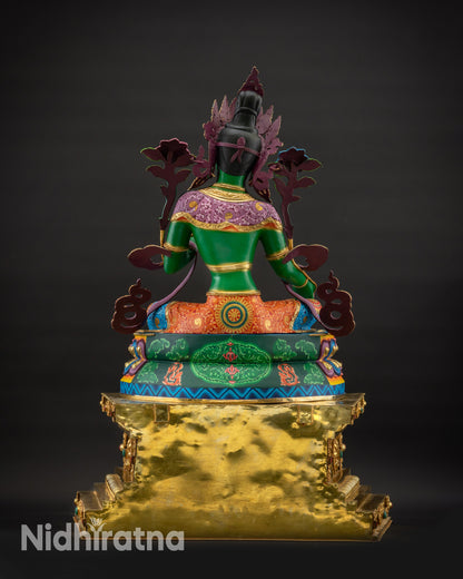 Back view of Green Tara statue on ornate hand-gilded Tibetan throne
