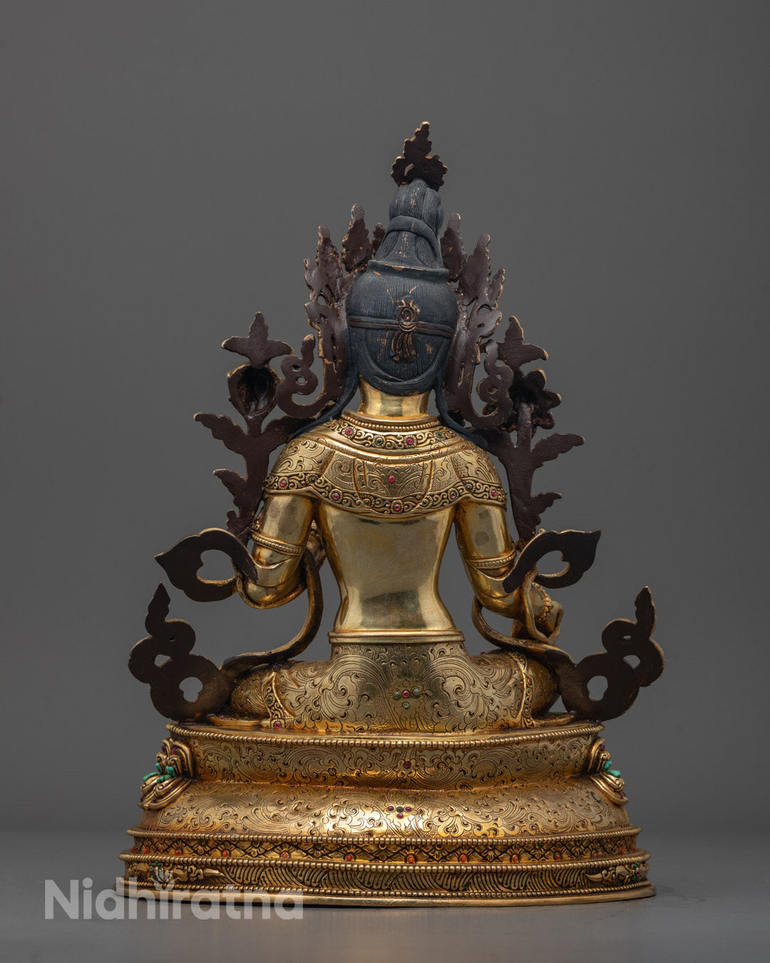 Back view of Green Tara statue seated on double lotus throne with vibrant semi-precious stones