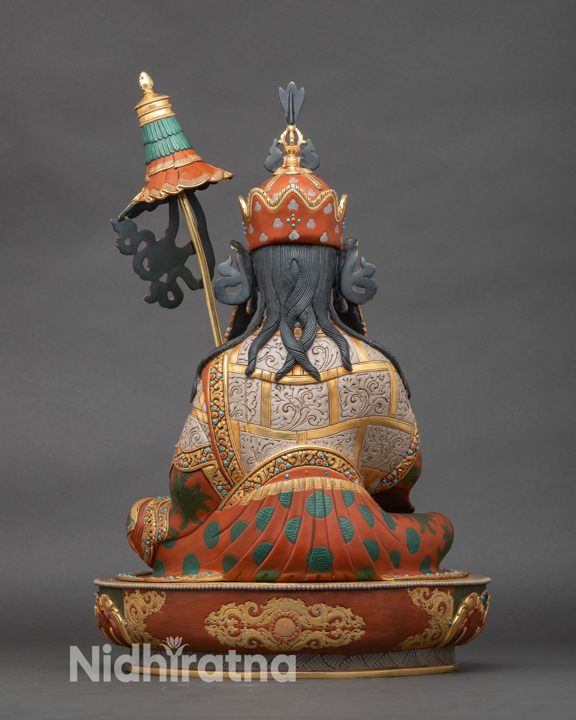 Back view of Guru Norlha statue highlighting robe carvings and lotus base