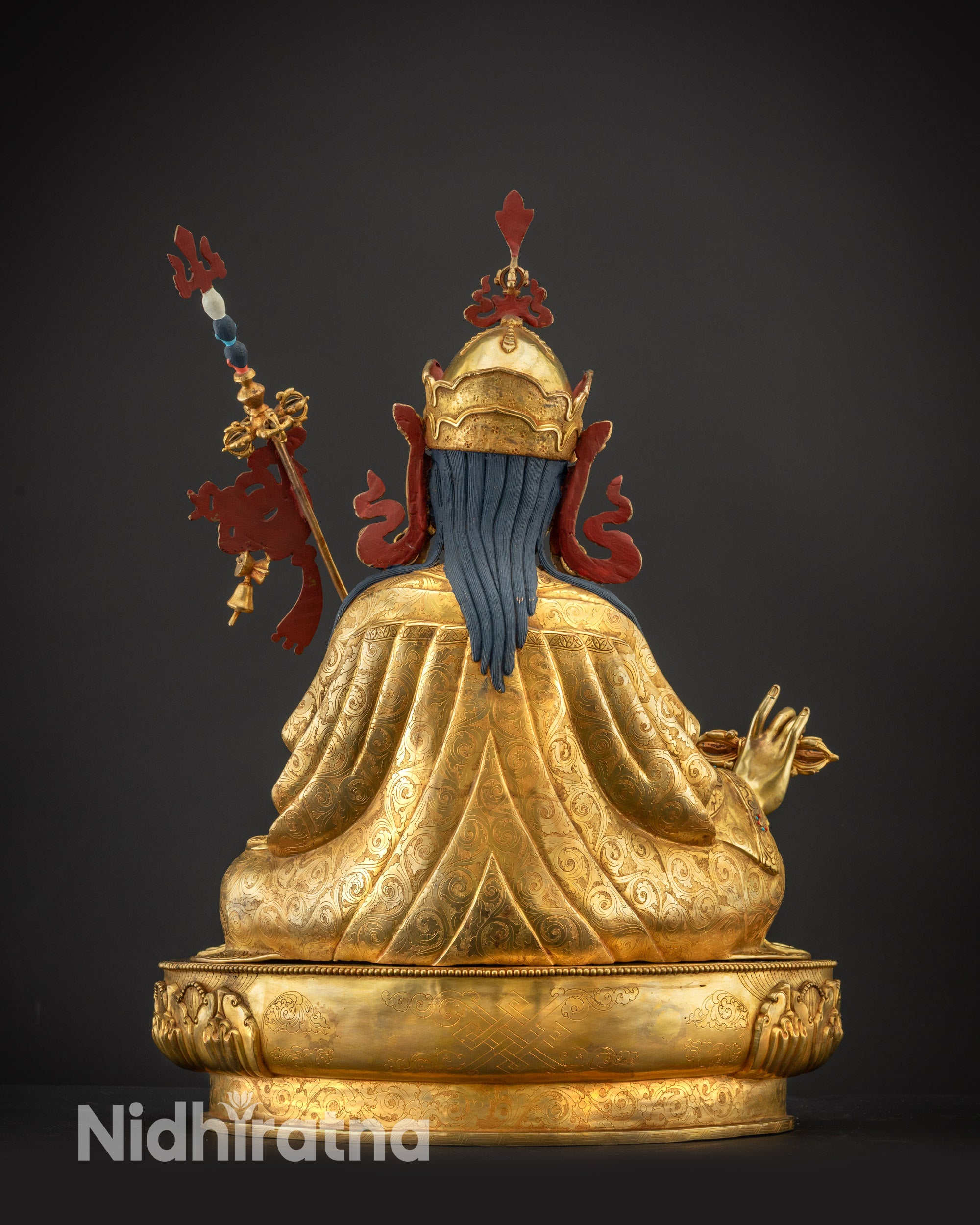 Back view of Guru Padmasambhava statue with engraved base and gilded robes
