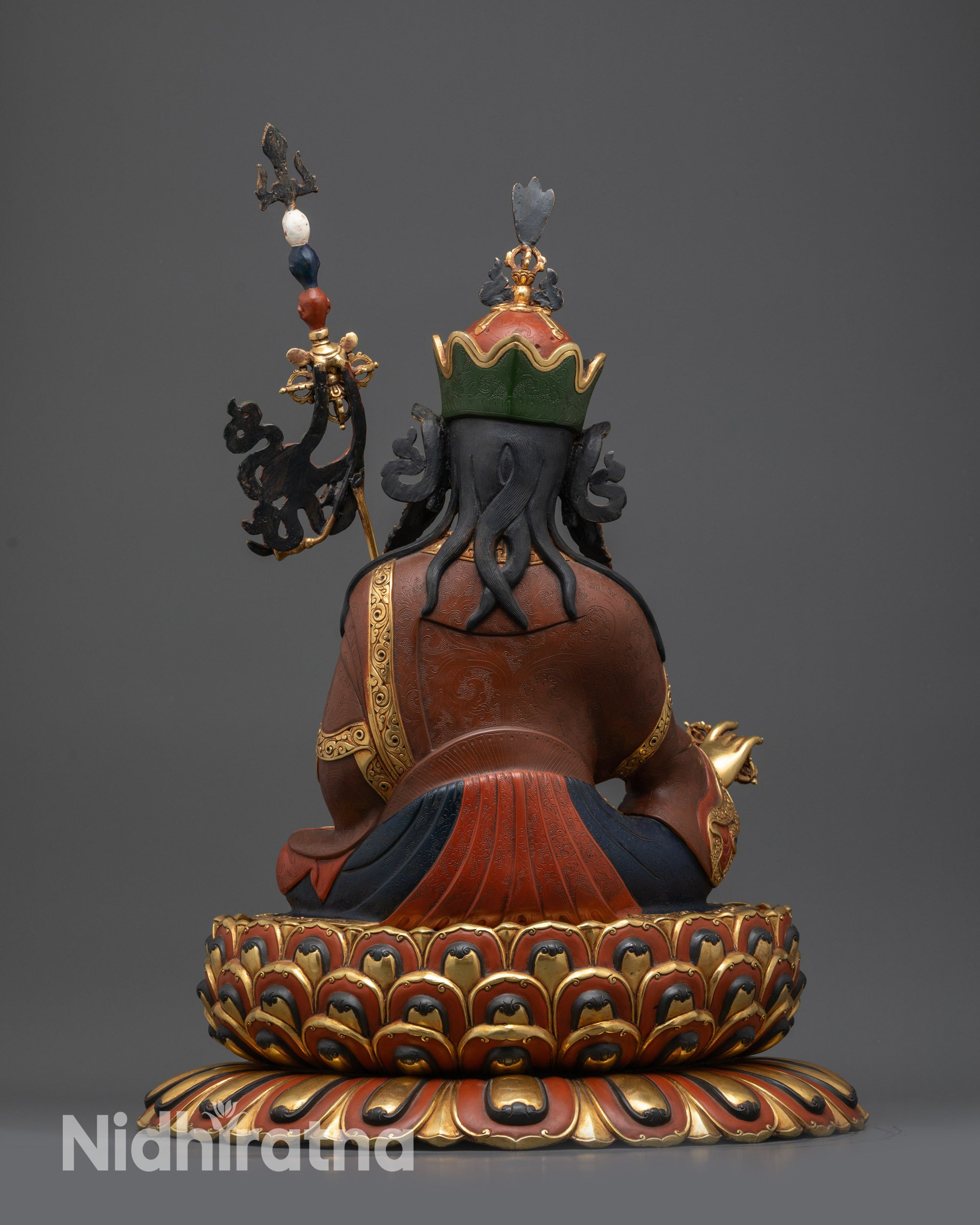 Back view of Guru Padmasambhava statue with intricate carvings, jewelry, and multi-layered lotus base
