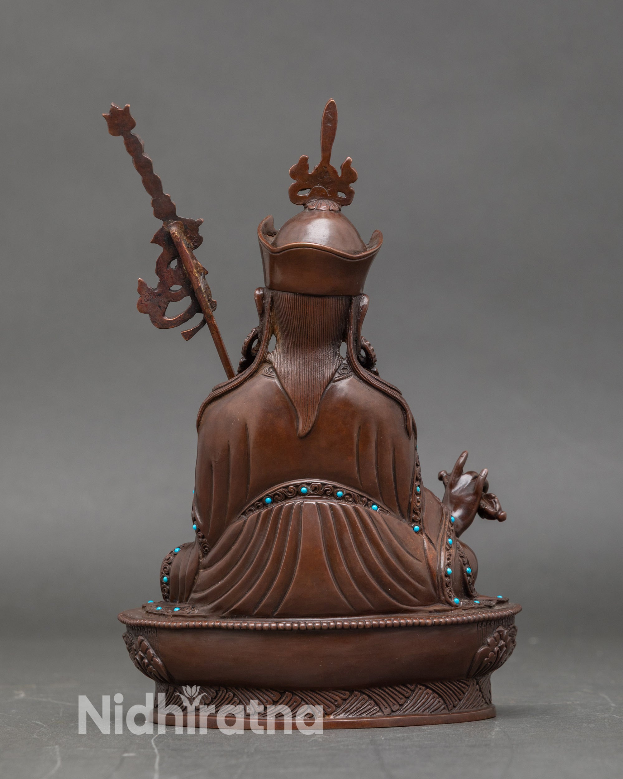 Back view of Guru Rinpoche Buddha statue, detailed lotus seat, Himalayan spiritual art