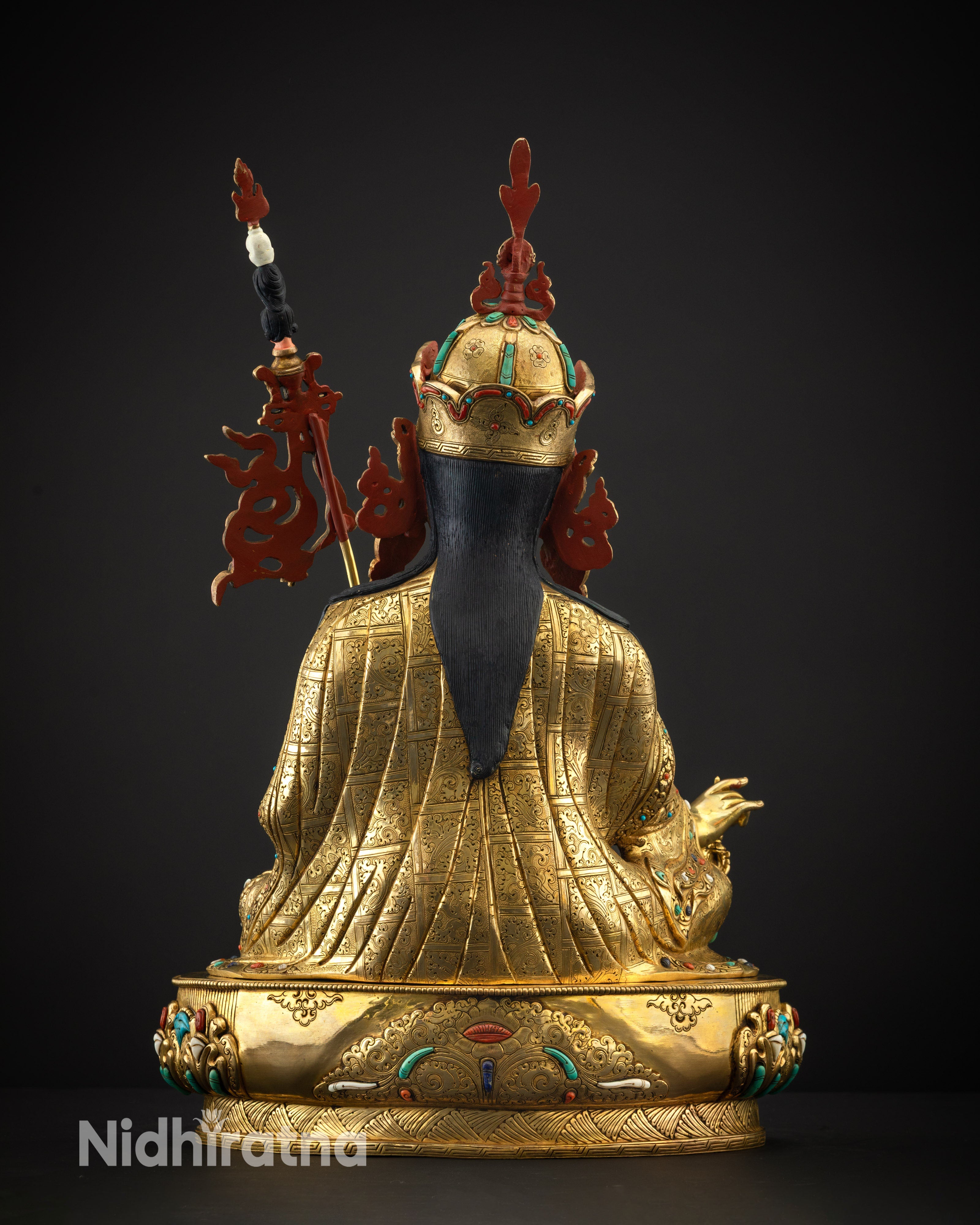 Back view of Guru Rinpoche showing engraved motifs and copper base details
